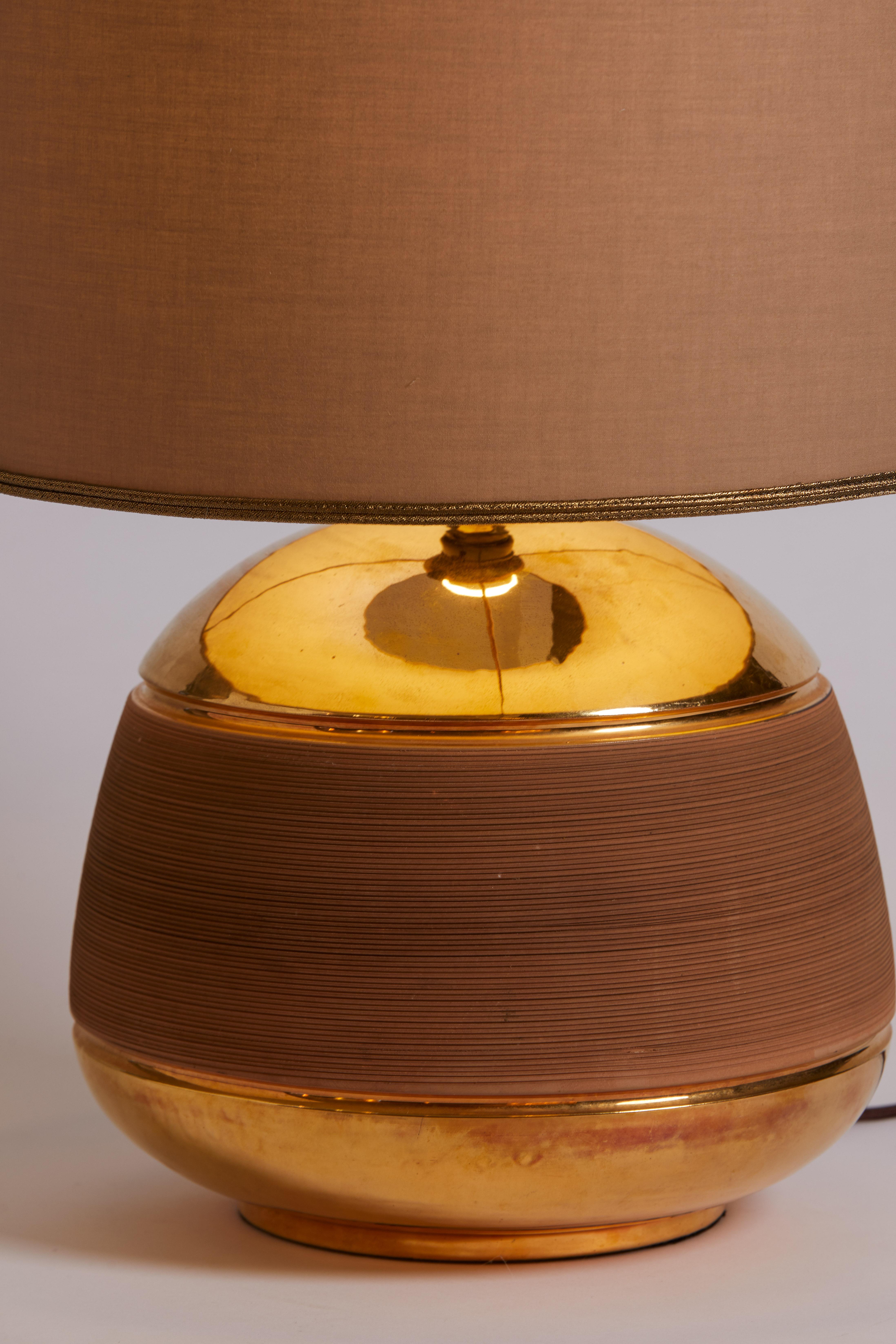 1960s French terracotta lamp with ribbed detail. New metallic linen lampshade from Paris.