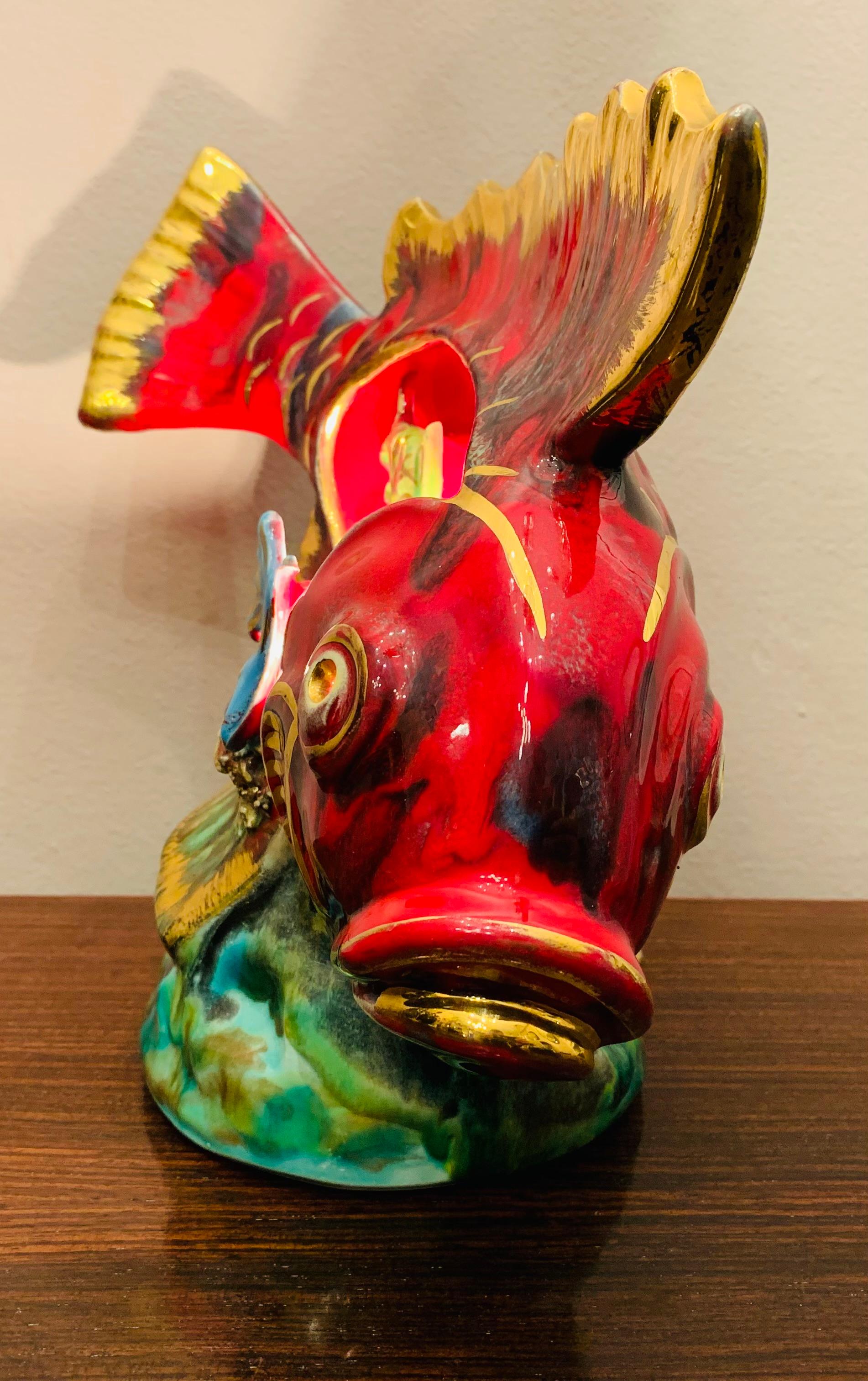 An interesting and kitsch Vallauris ceramic decorative table lamp from the 1950s/1960s of a large red and gold fish and underwater scene with three swimming fish.

The fantasy wonderland under the seabed is illuminated by a single E14 screw in