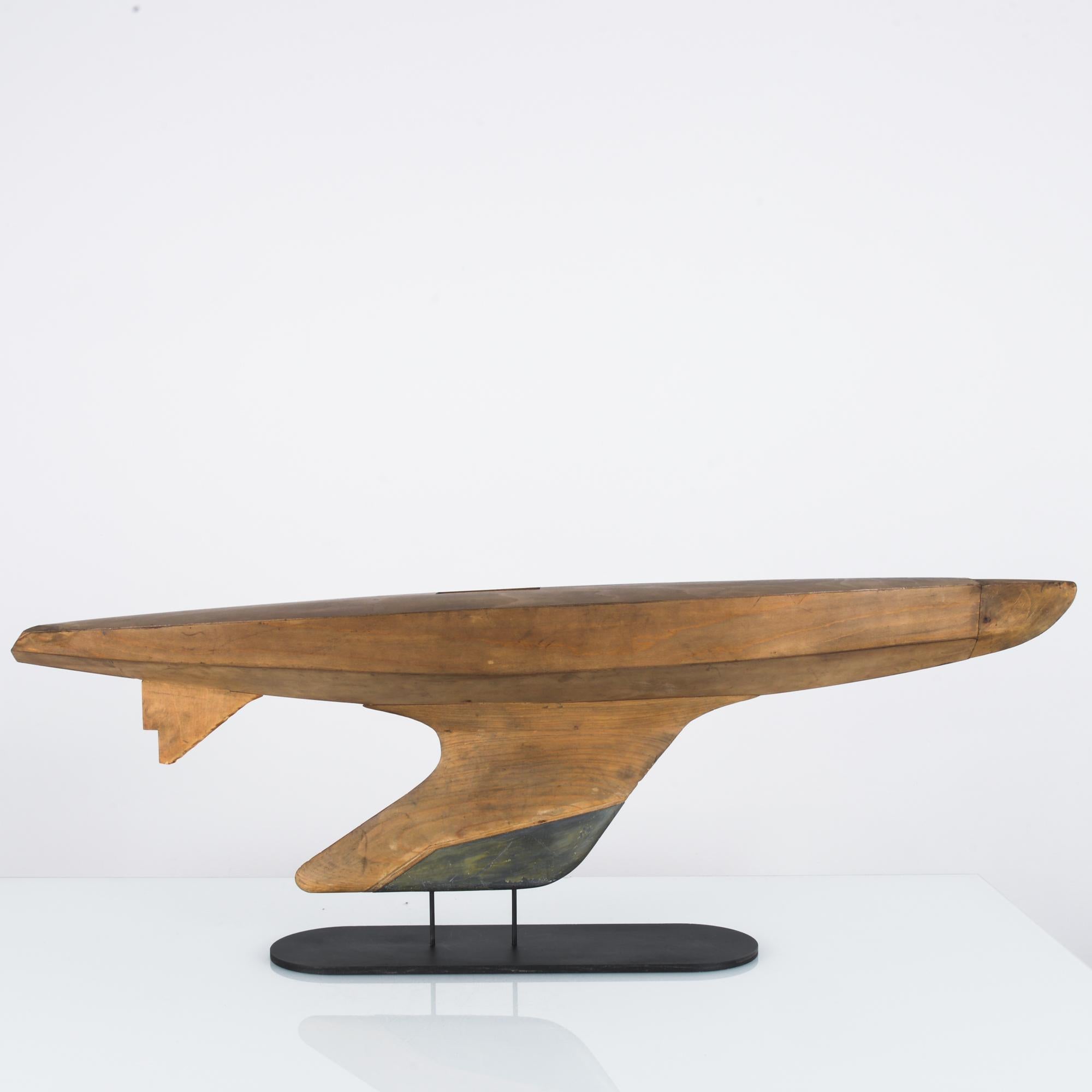 This wooden boat was made in France, circa 1960, and recalls the tranquility of lapping waves and the coastal breeze. The boat has a dynamic form and a smooth finish, which highlights its distinctive wood grain. With the bottom of the keel mounted