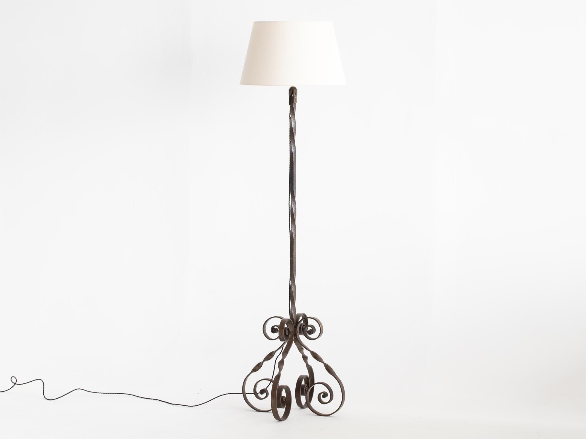 A wrought iron floor lamp with twisted stem, raised on a scrolled base. French, c. 1960s.

Professionally re-wired. New tapered calico shade included.

Height (with shade): 172 cm (67.7 