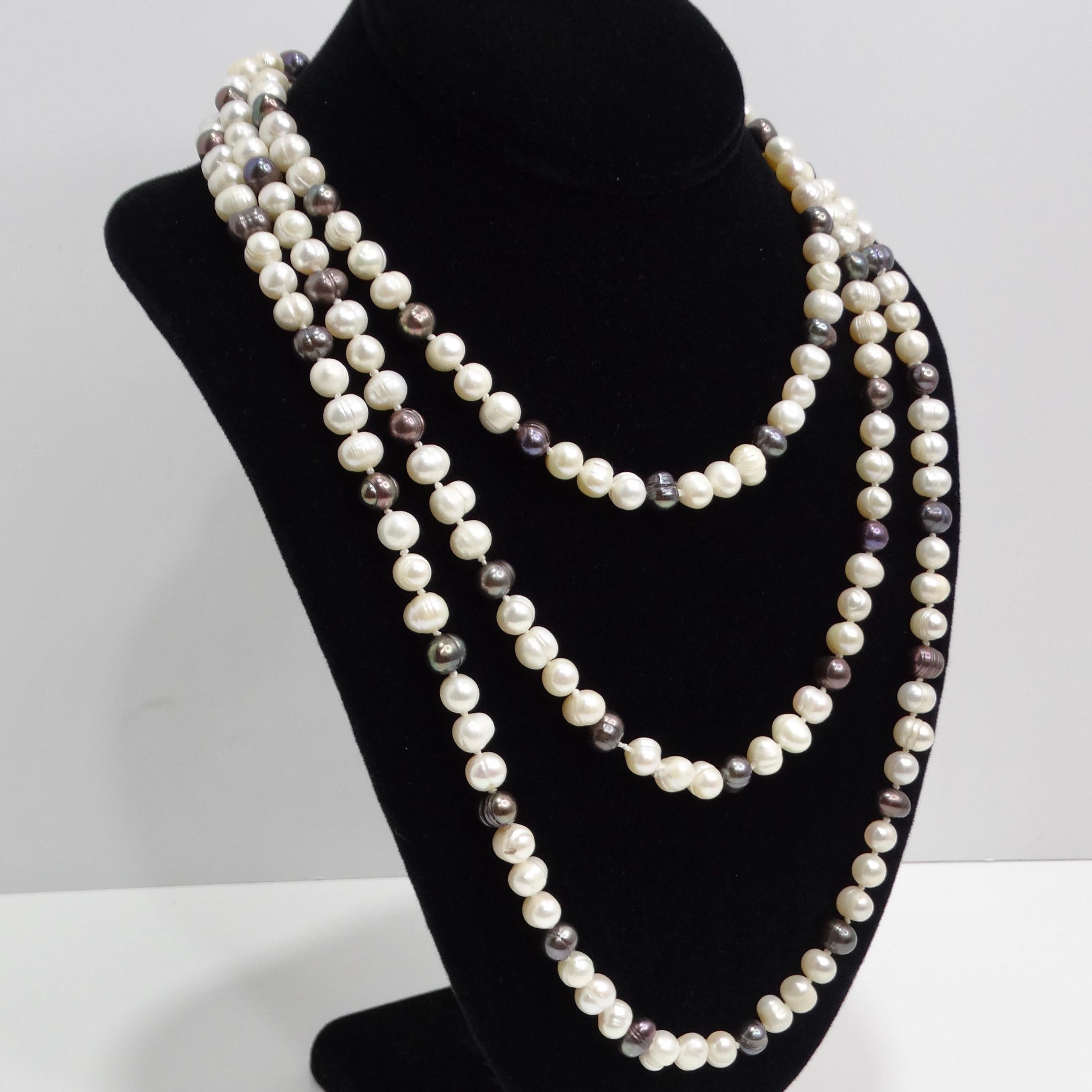 Introducing the 1960s Freshwater Pearl Necklace, a vintage extra-long beaded necklace that radiates opulence and luxury. This stunning piece features a captivating combination of black and white freshwater pearls, each offering a unique lustrous