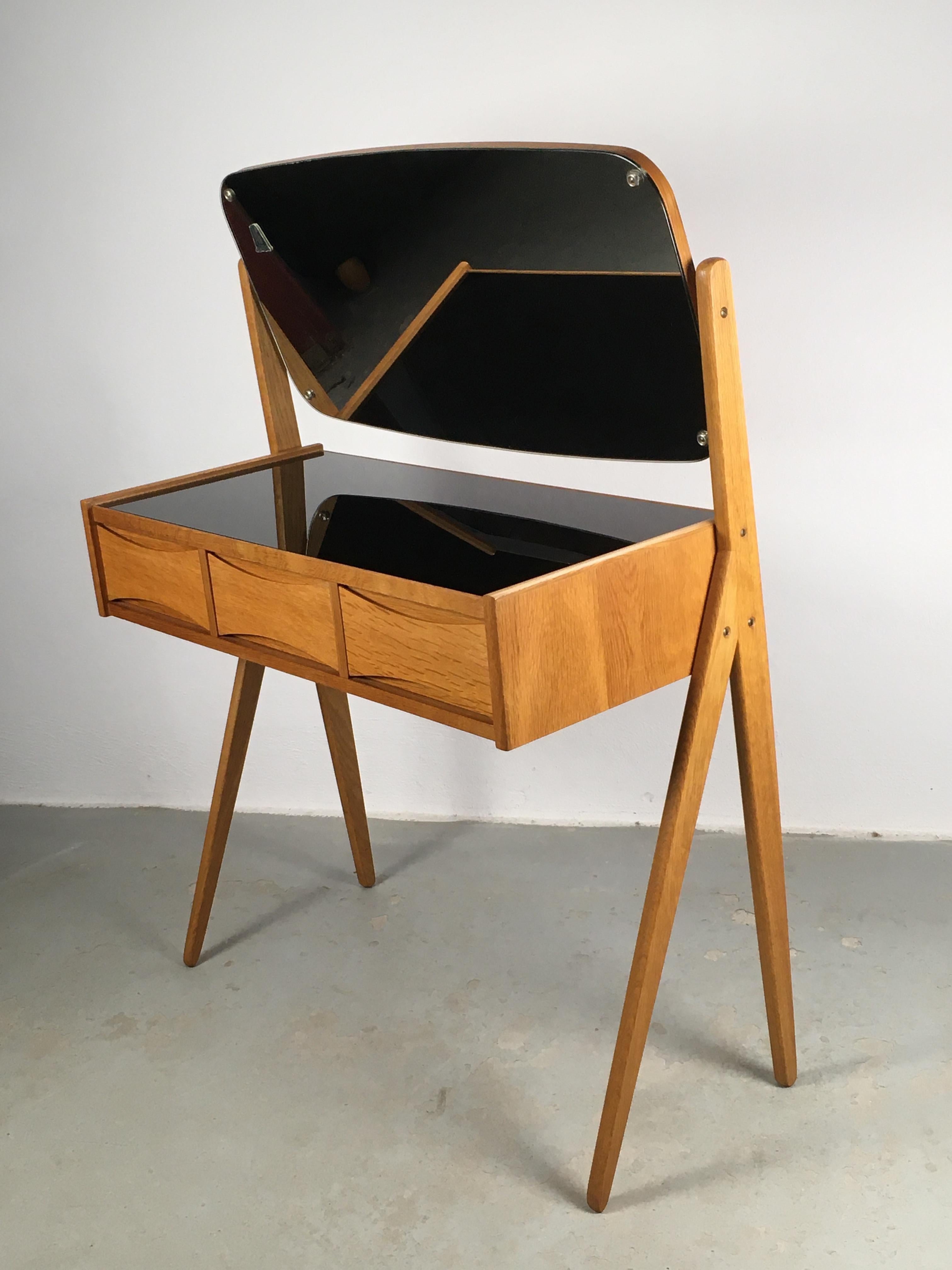 1960s Fully Restored Arne Vodder oak dressing / vanity table by Oelholm Moebelfabrik designed in the 1950´s.

Elegant oak dressing-/vanity table with spilt legs, adjustable mirror and the quintessential bow tie grips on drawers top and bottom that