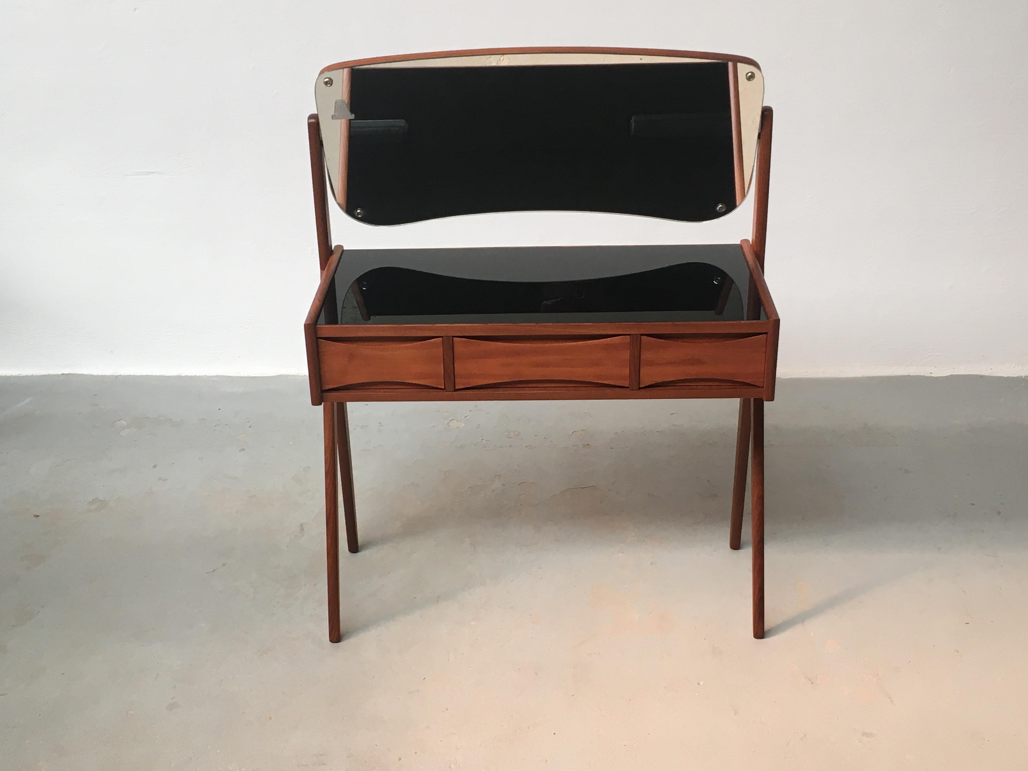 1960s Fully Restored Arne Vodder Teak dressing table by Oelholm Moebelfabrik designed in the 1950´s.

Elegant teak dressing-/vanity table with spilt legs, adjustable mirror and the quintessential bow tie grips on drawers top and bottom that are