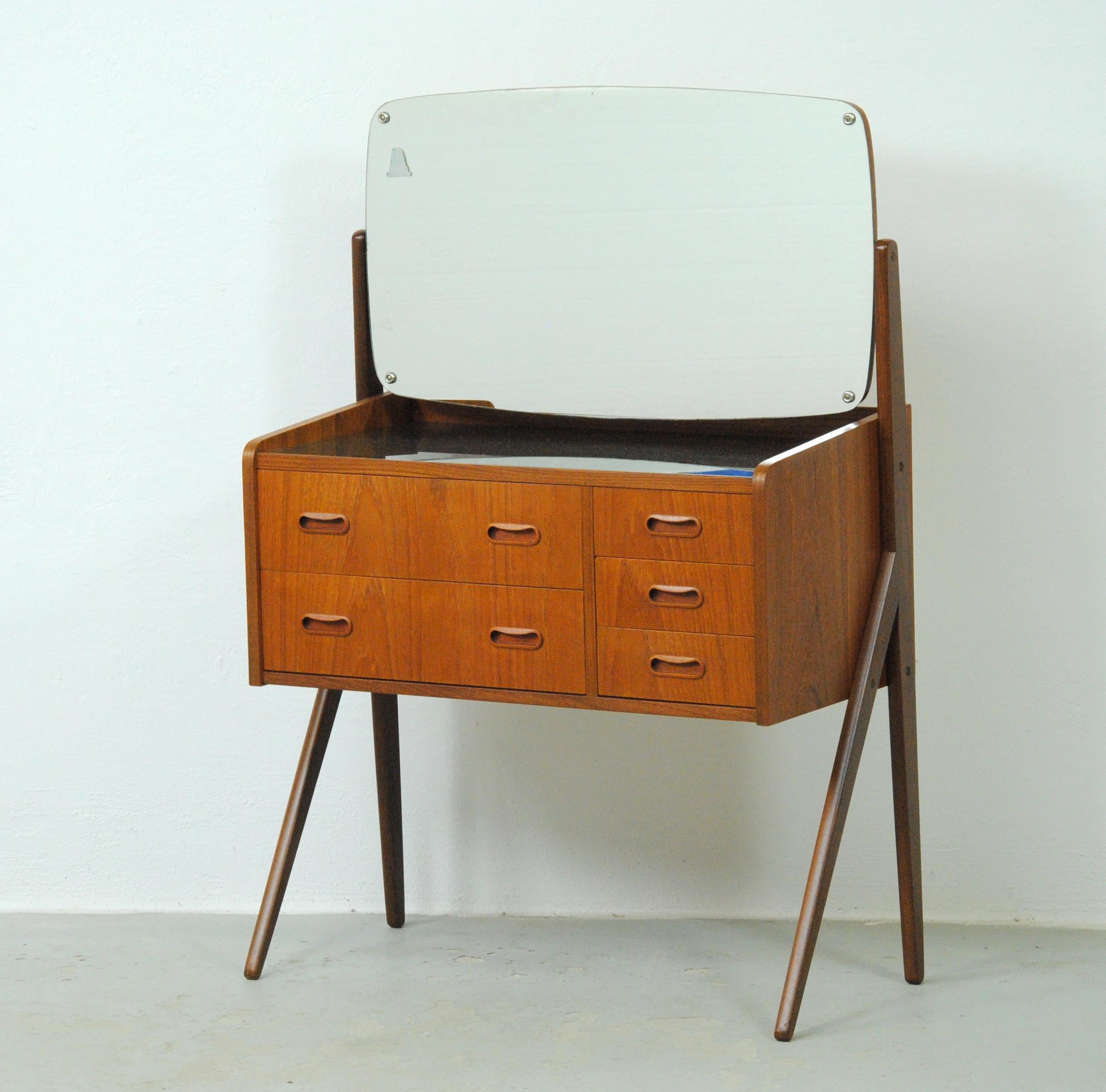 Danish teak dressing - vanity table from the 1960s.

The vanity table features a large adjustable mirror, an original black glass table top and 5 spacious drawers with room for what you need at the vanity table.

The table has been fully