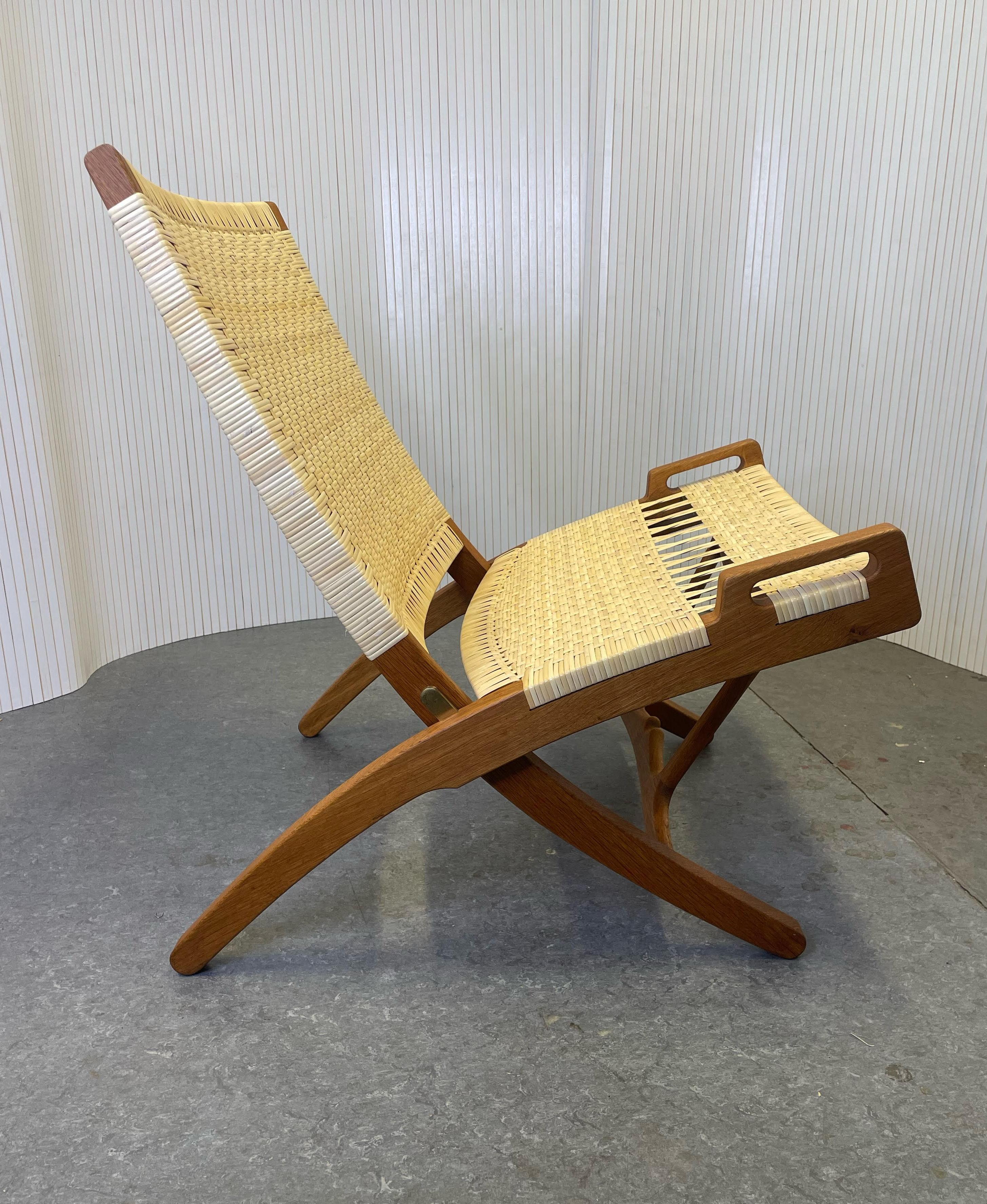 Chaise pliante Hans J. Foldes modèle JH 512 des années 1960 entièrement restaurée, rotin et cannage neufs.

Le modèle 512 de Hans J. Wegners, conçu en 1949, est considéré comme l'une de ses œuvres les plus importantes et les plus emblématiques. La
