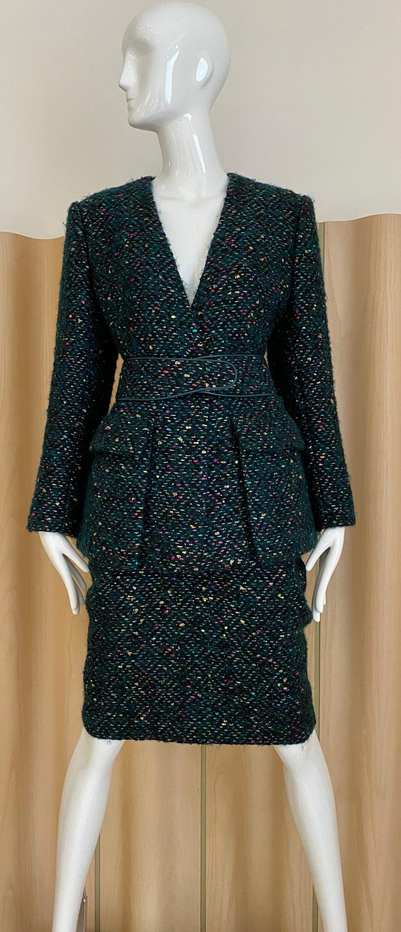 Vintage Galanos Skirt Suit from the 1960’s in a cashmere and wool boucle with metallic threads woven into it. Jacket has a v neck no collar, one center button, two
flap patch pockets and a contoured belt trimmed in leather and metal fasteners. Knee