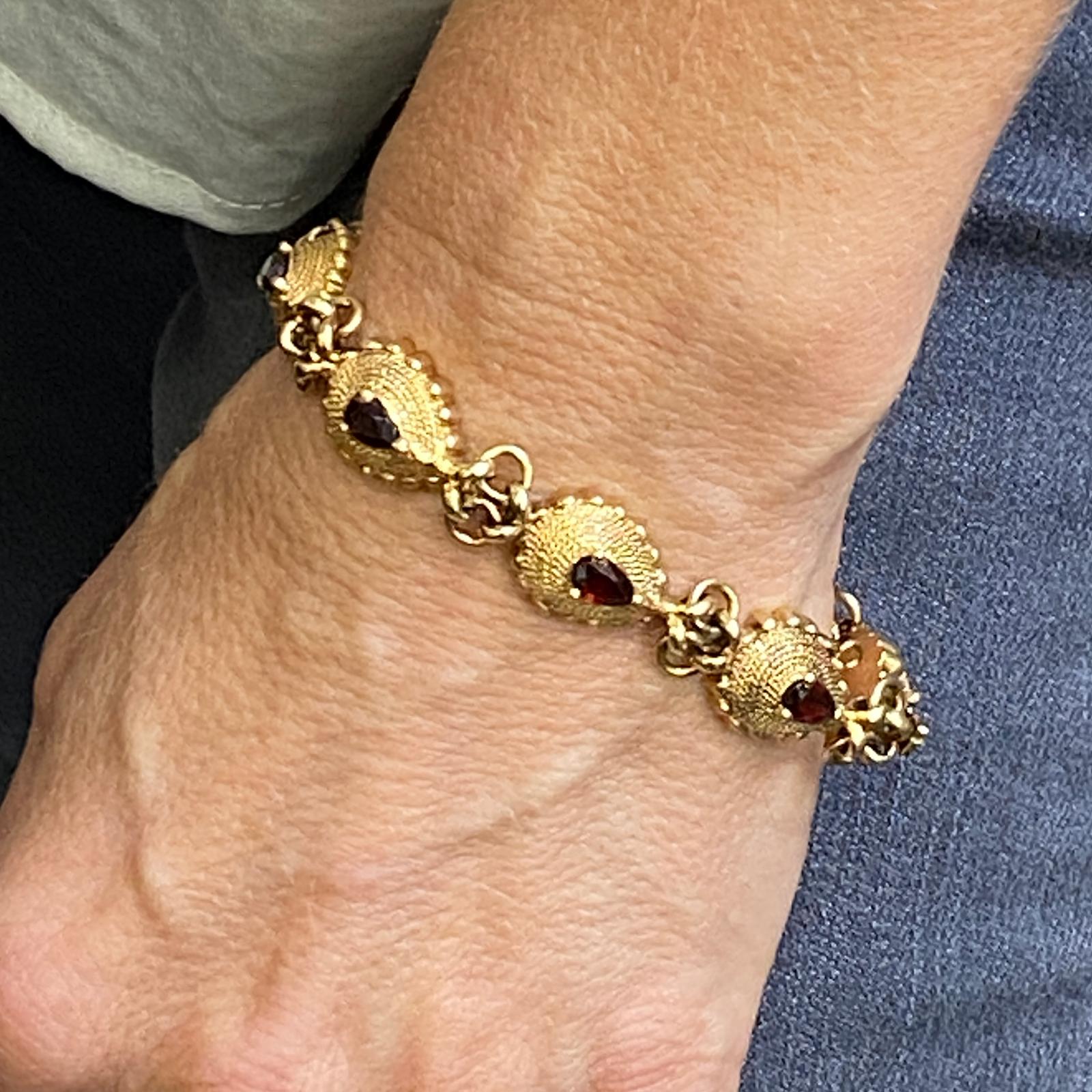 1960's Garnet link bracelet bracelet fashioned in 14 karat yellow gold. The bracelet features 8 pear shape garnet gemstones weighing approximately 3.00 carat total weight.  The bracelet measures 7.25 inches in length. 