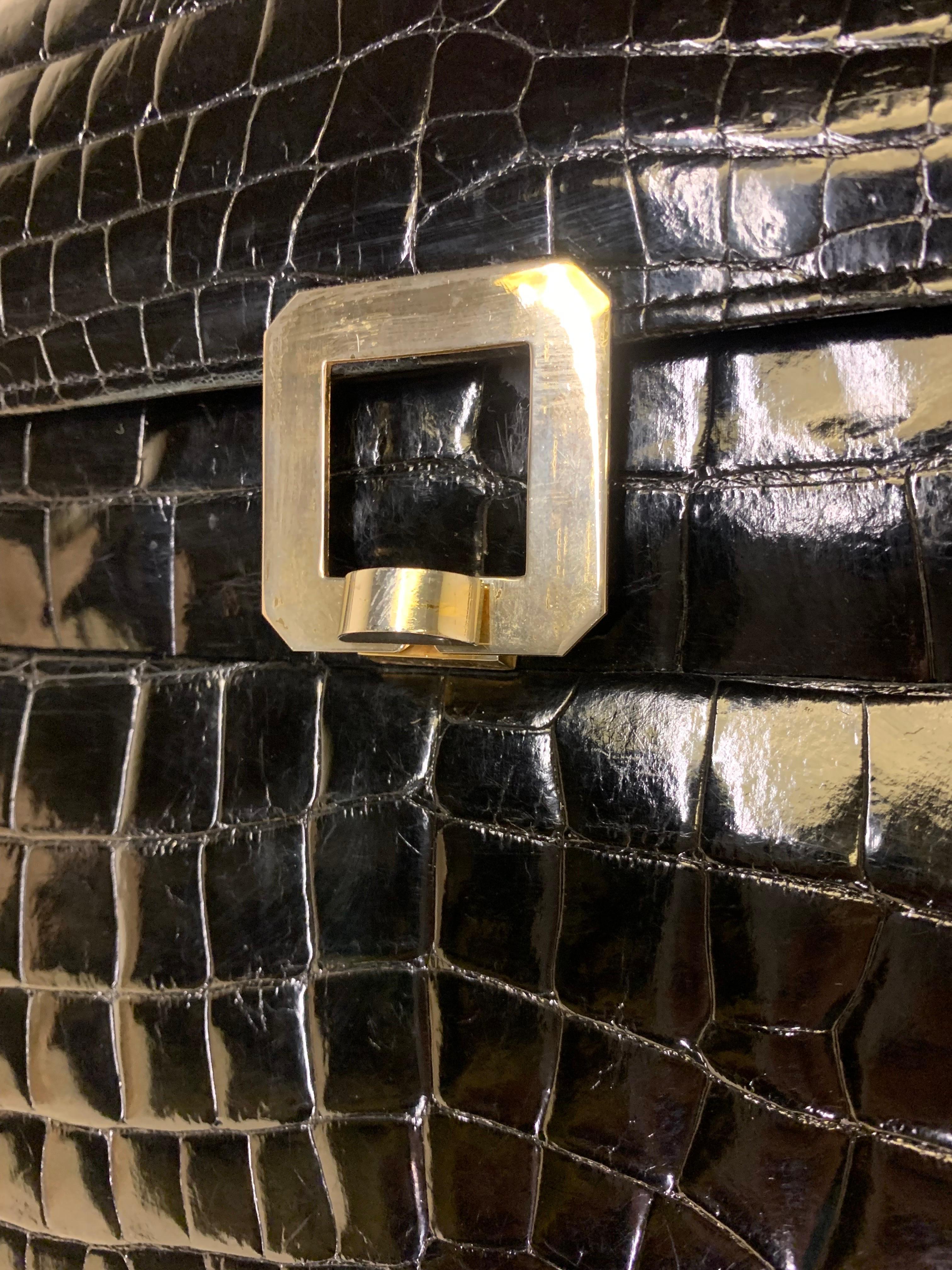 1960s Genuine black center-belly alligator skin handbag: Tailored, accordian-pleated and structured with a padded handle, front flap closure and brushed silver-tone buckle. Medium sized. Excellent condition. 