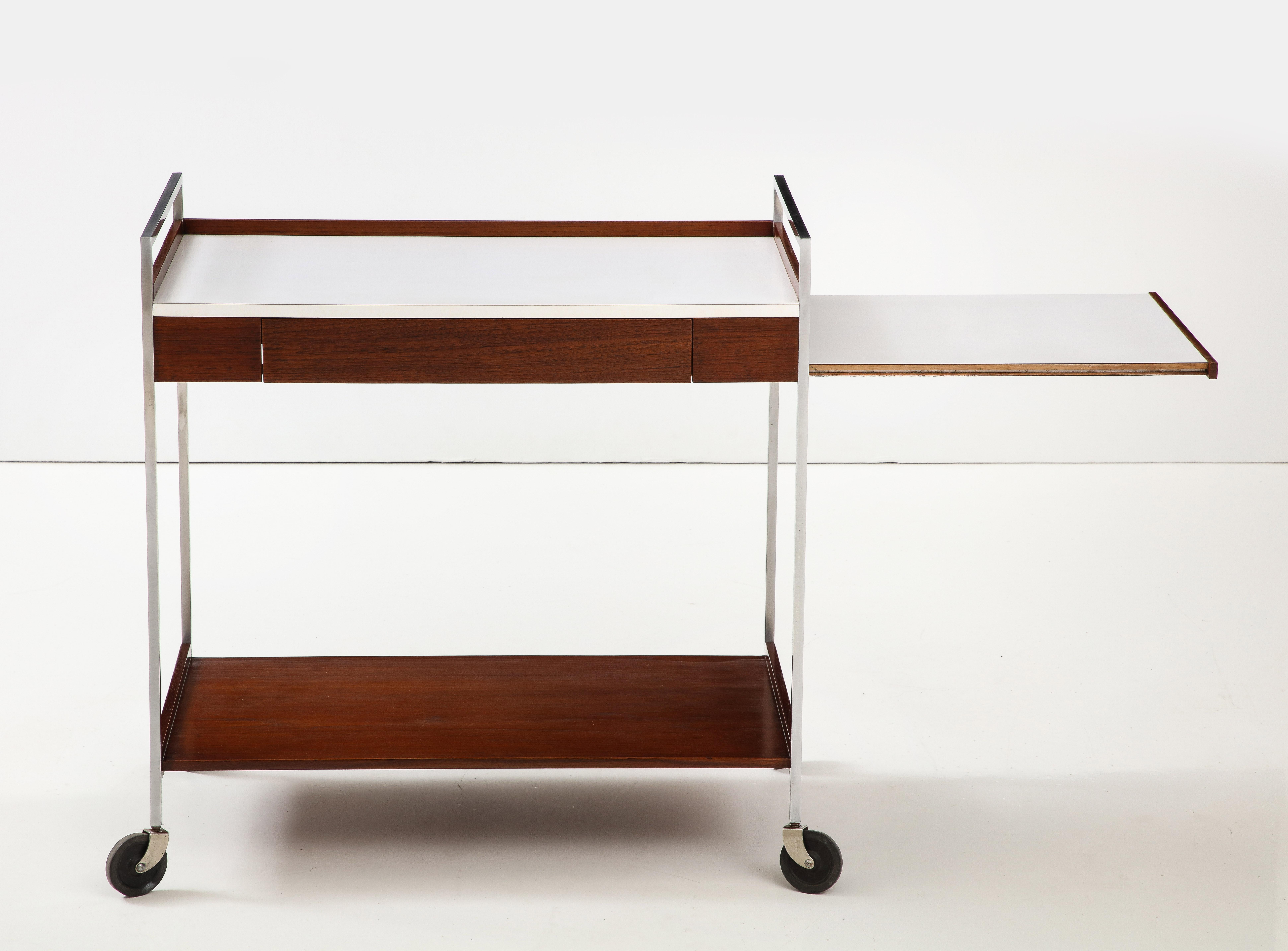 1960's mid-century modern walnut and chrome bar cart designed by George Nelson for Herman Miller, with a single drawer and pull out tray, in vintage condition with minor wear and patina due to age and use, lightly restored.
