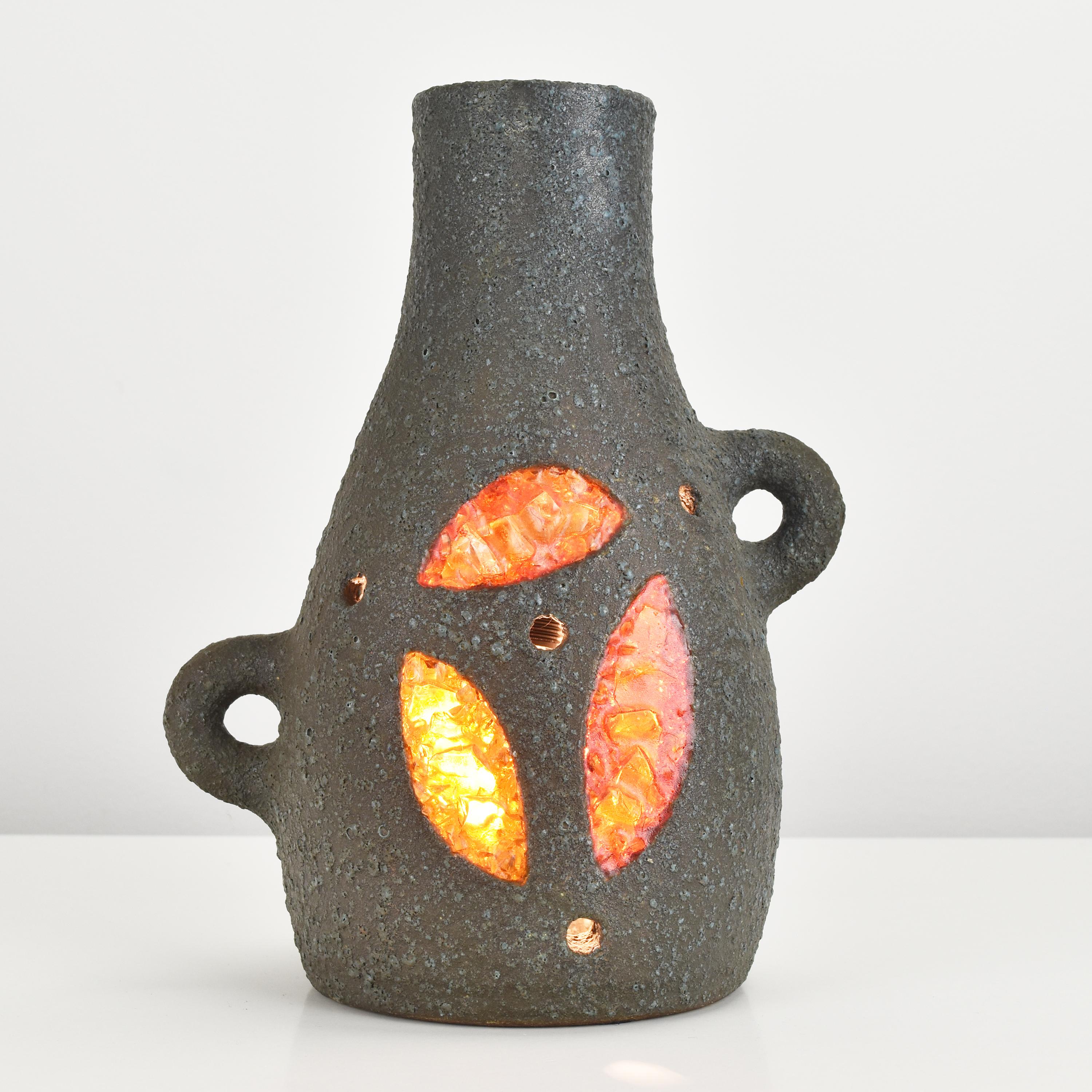 This Georges Pelletier ceramic table lamp is a unique and striking piece, shaped like a volcano. Made in the 1960s by the French company Accolay, this table lamp features a ceramic base with resin inlays, giving it a rich and textured appearance.