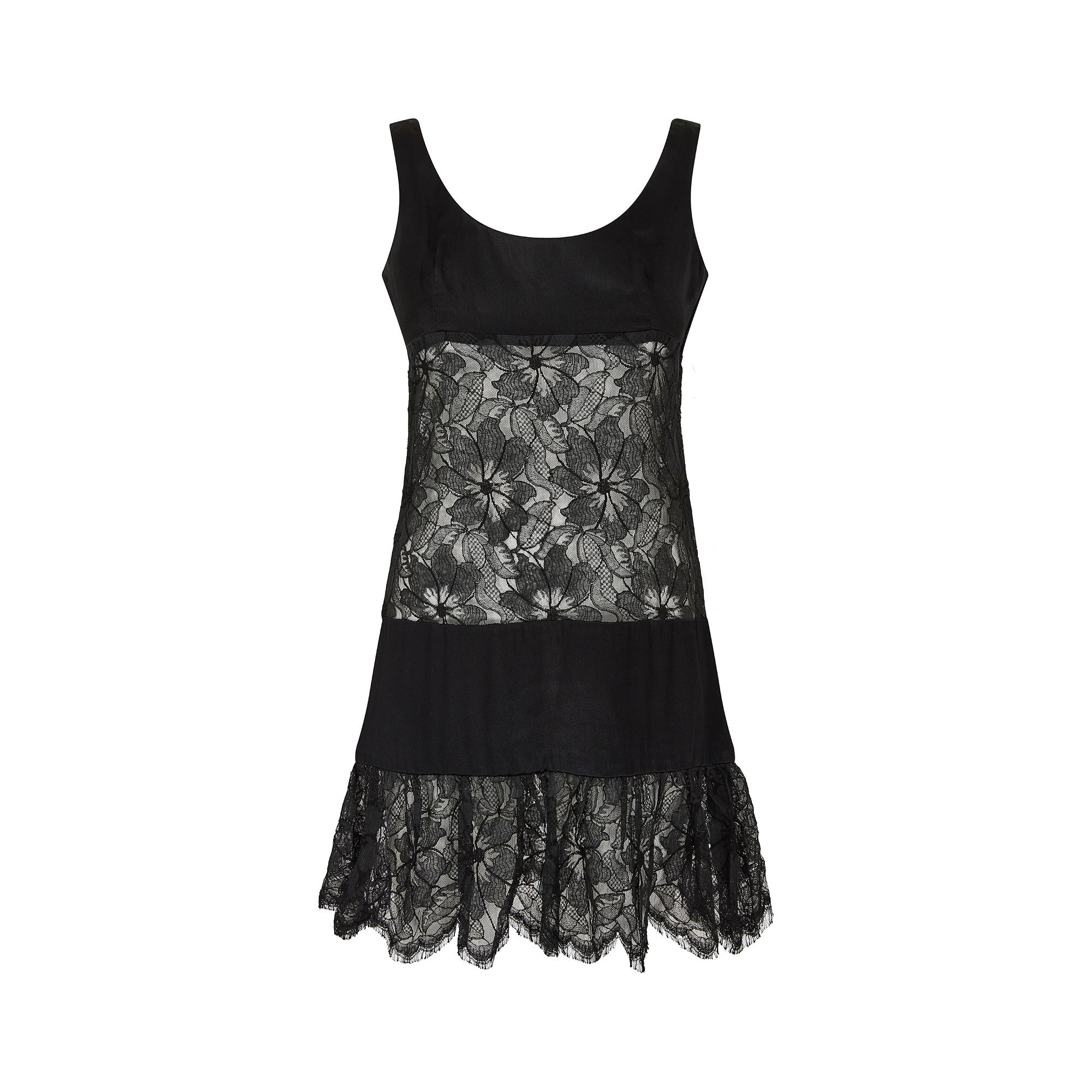 This mid to late 1960s cocktail or party dress is composed of three tiers and a lace ruffle panelling at the bottom of the dress. Panels are made of a transparent black floral lace and black satin. The satin fabric appears to have a grain, and is