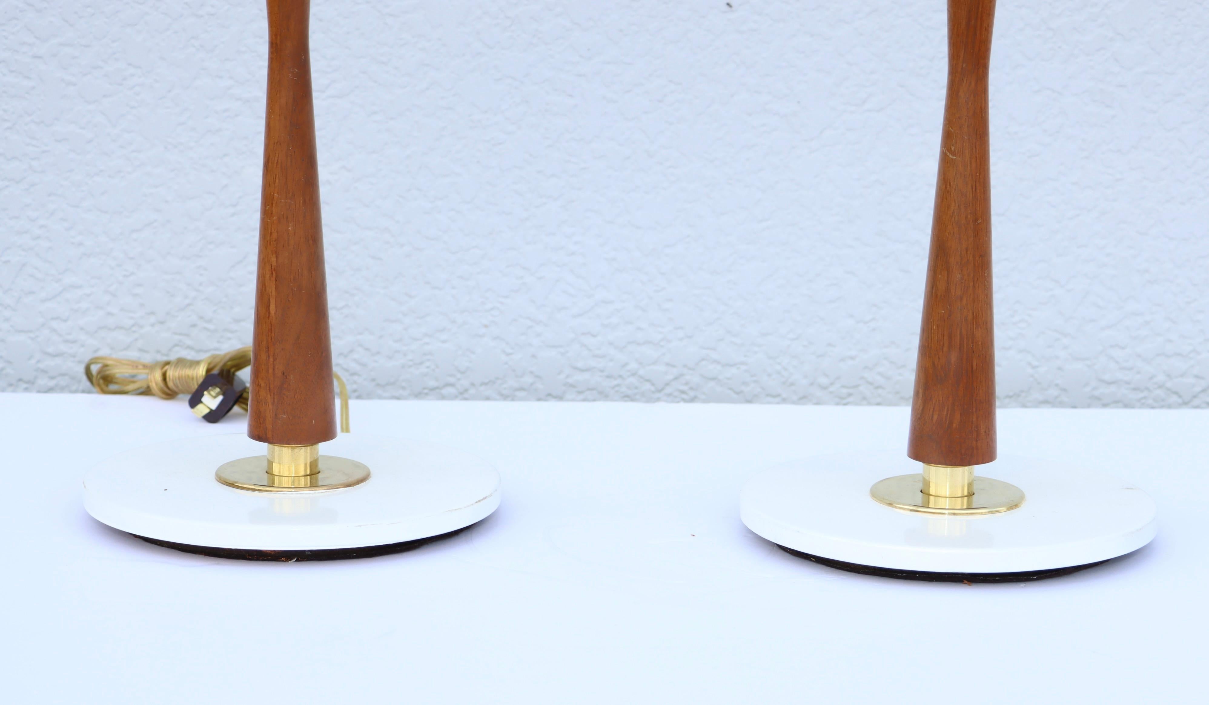 Lampes de table en laiton émaillé et noyer du milieu du siècle dernier, conçues par Gerald Thurston pour Lightolier, récemment recâblées, avec quelques usures et patines dues à l'âge et à l'utilisation, la base est un peu usée.
