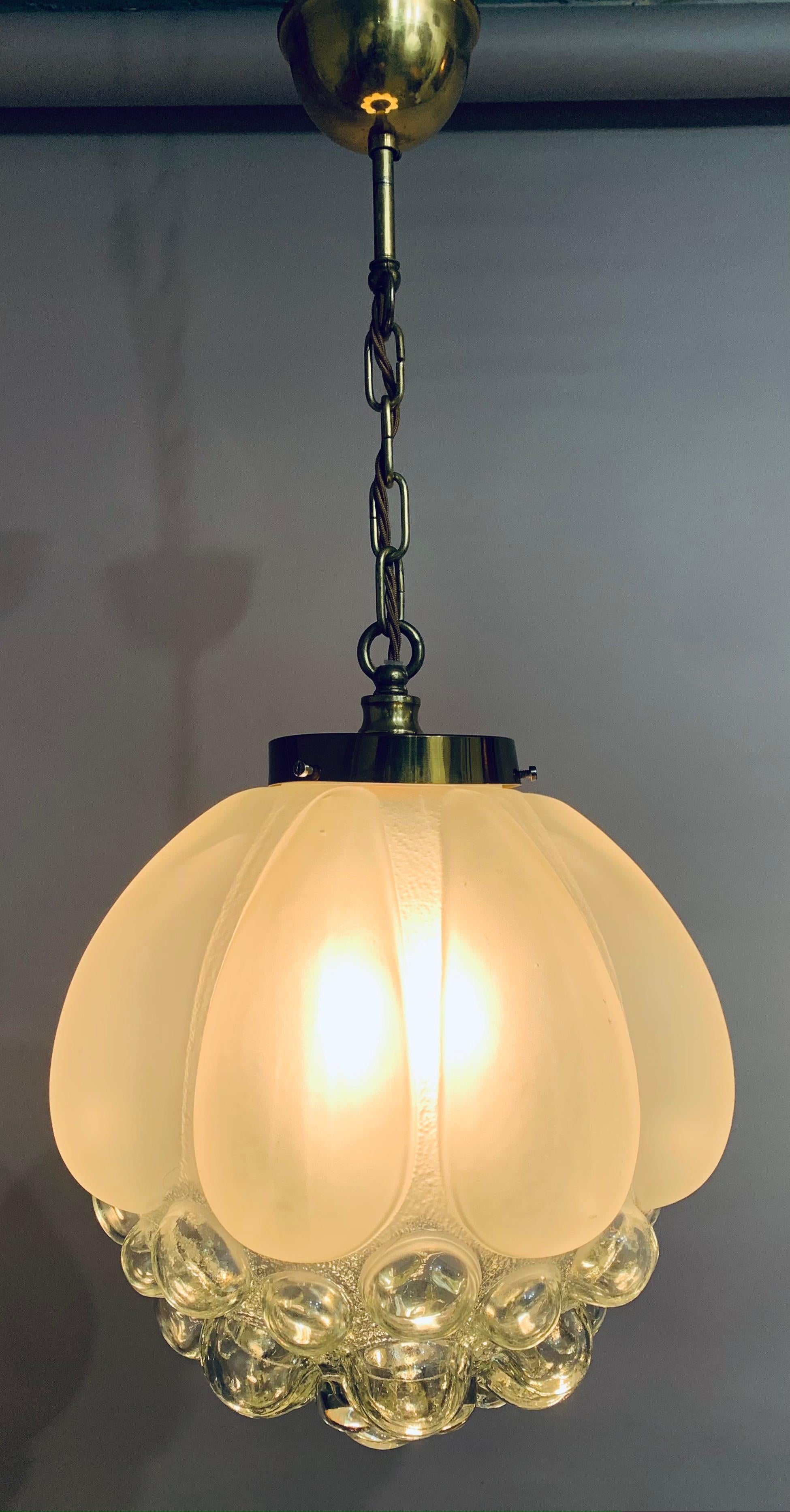 An interesting and beautifully designed hanging glass pendant lamp with frosted glass larger elongated bubbles at the top with clear glass bubbles underneath. The shade hangs from a polished brass fitting with a lovely deep patina which is secured