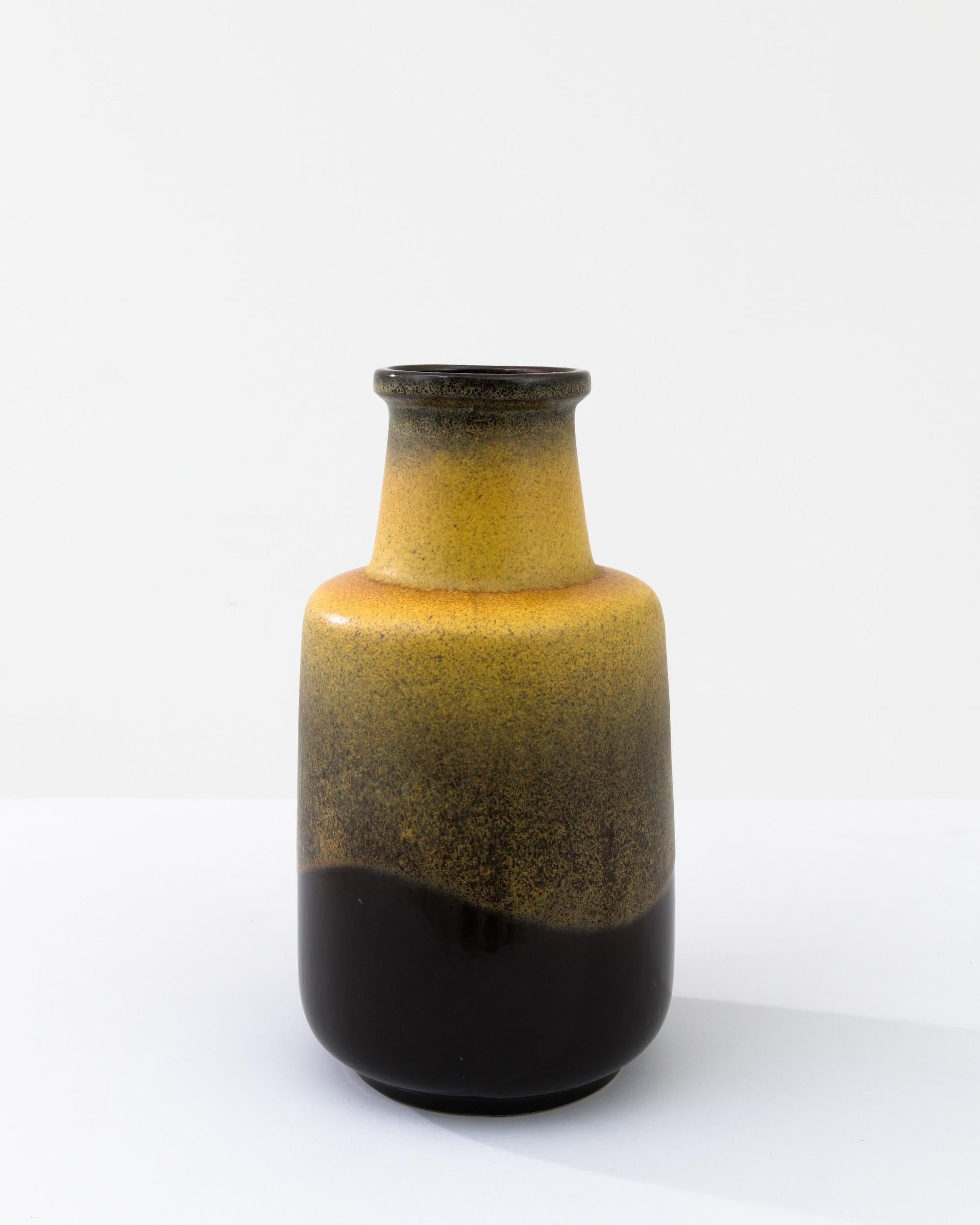 Combining time-honored craftsmanship with a sophisticated glaze, this vintage ceramic vase possesses an innate elegance. Made in West Germany in the 1960s, the stout neck and circular handle create a silhouette reminiscent of a simple stoneware jug,