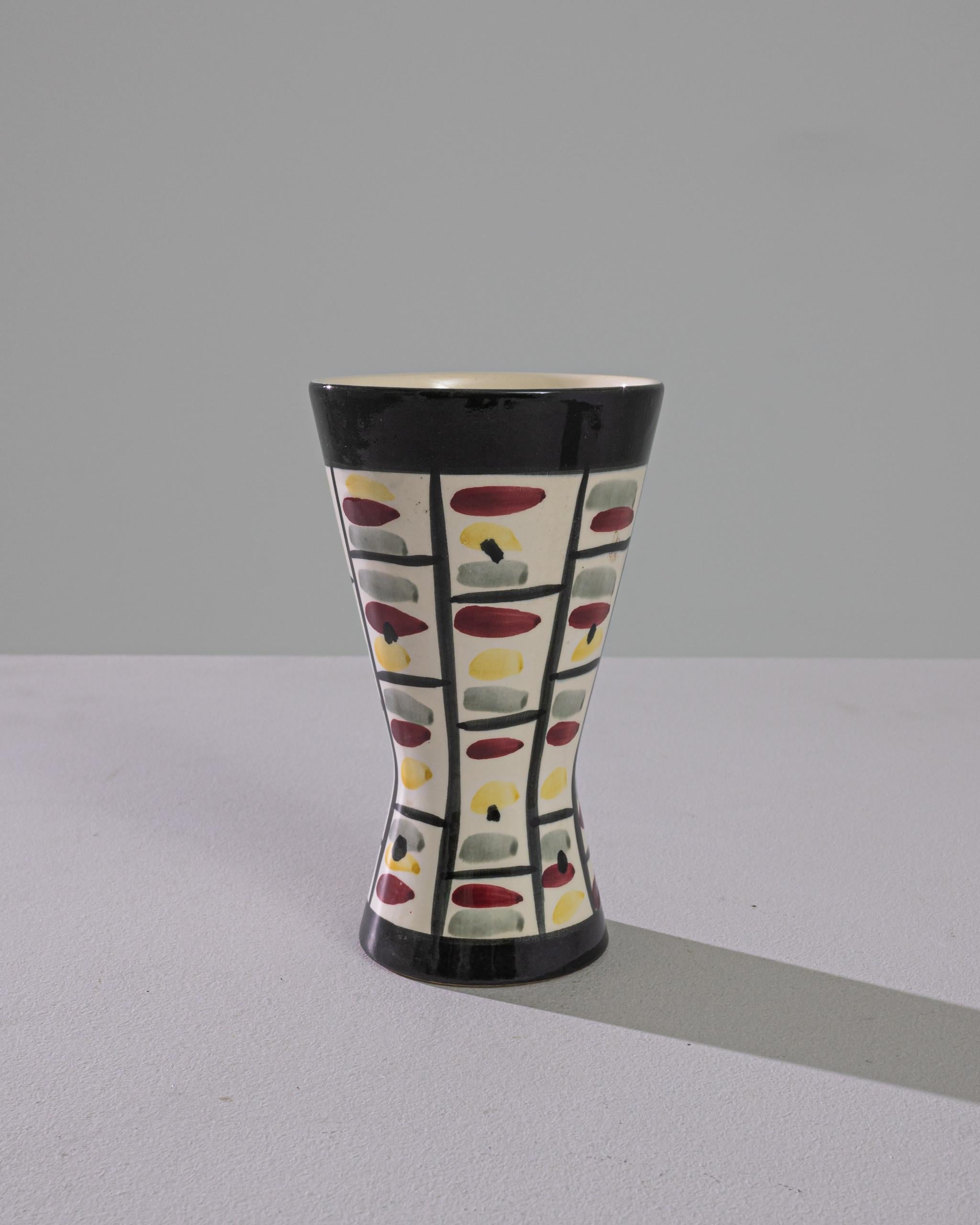 This striking 1960s German Ceramic Vase by Strehla Keramik is a vibrant artifact of mid-century modern design. Its unique tapering form is a testament to the era's love for geometric silhouettes and functional art. Adorned with a playful array of