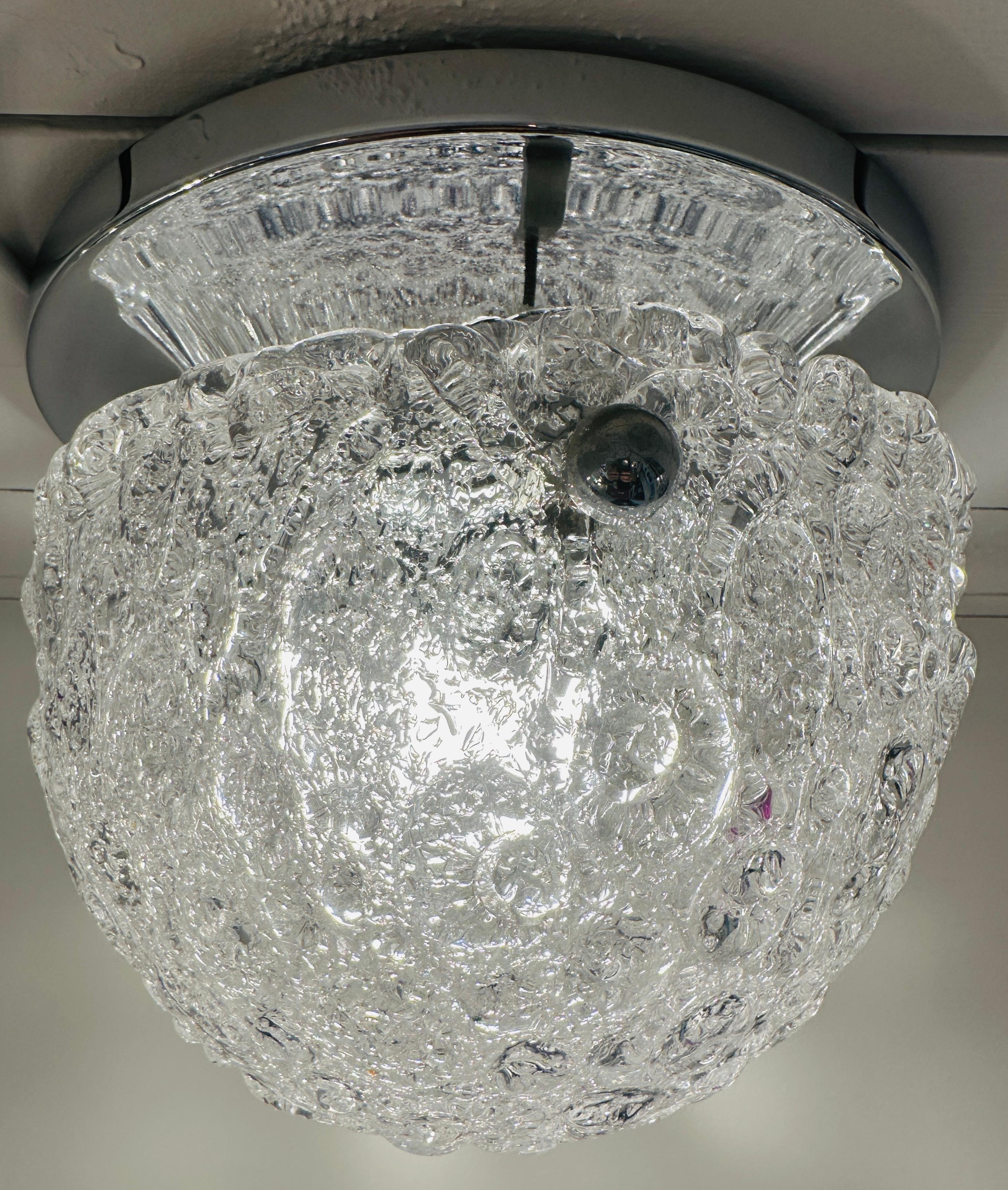 Kuppelförmige Deckenleuchte aus Milchglas aus den 1960er Jahren, aufgehängt an einem runden Rahmen aus poliertem Chrommetall. Hergestellt von Hillebrand Leuchten.

Der gewölbte Murano-Glasschirm weist ein sich wiederholendes, gewirbeltes Muster auf,