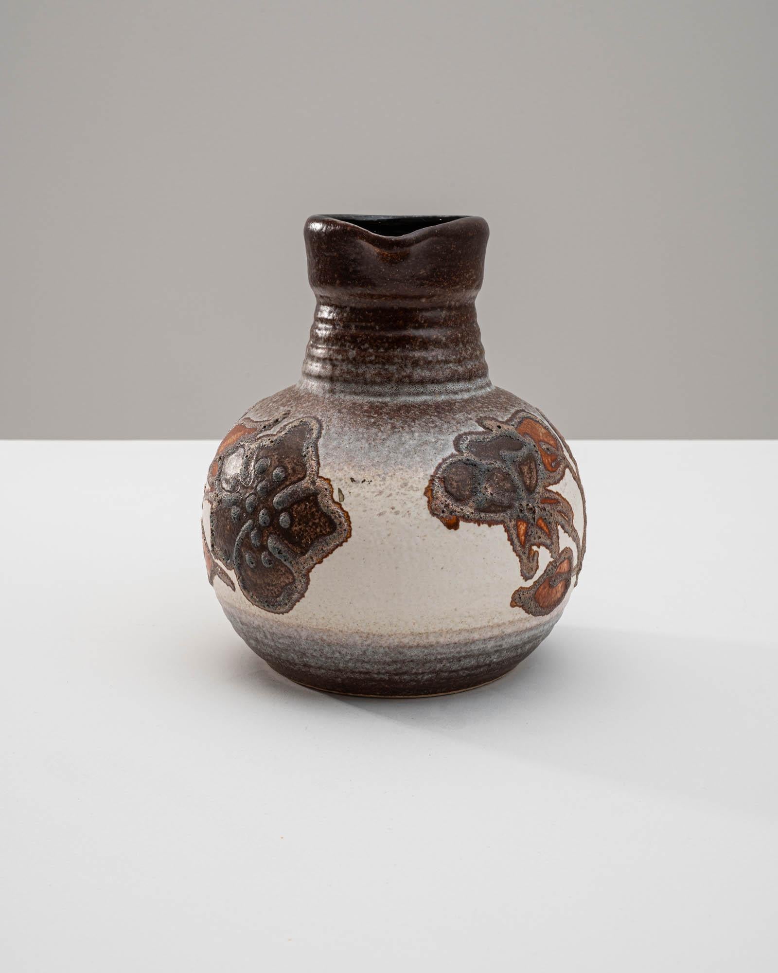 Indulge in the timeless beauty of this 1960s German “W. Germany” Ceramic Vase, characterized by its wide base adorned with an elegant floral design. The transition from a elegant crème at the base to a rich brown hue towards the top adds depth and