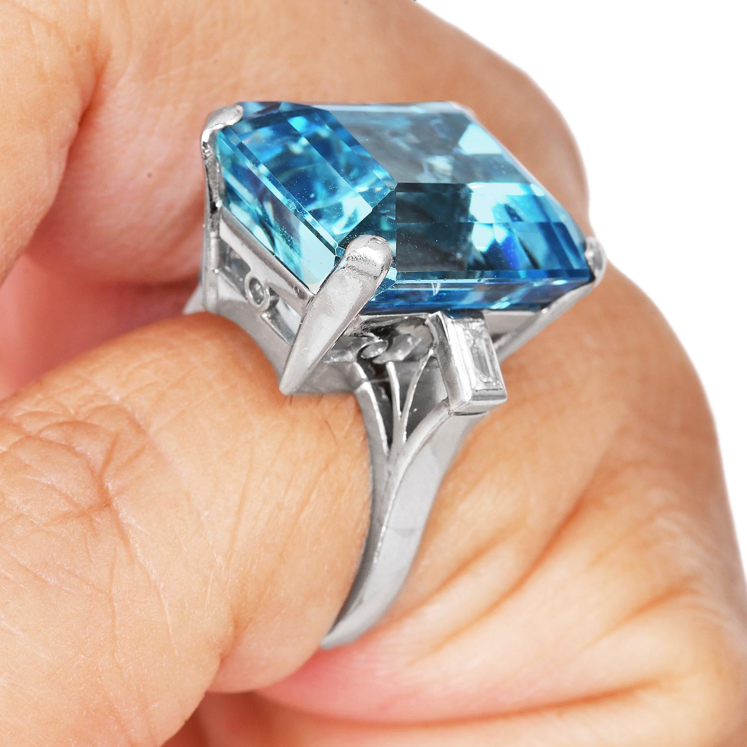 Presenting a three-stone cocktail ring with a GIA-certified large Aquamarine set with two natural diamonds on a platinum mounting. 

Aquamarine is reported to be approx. 20 carats. From Natural Beryl species in Octagonal Step cut transparent