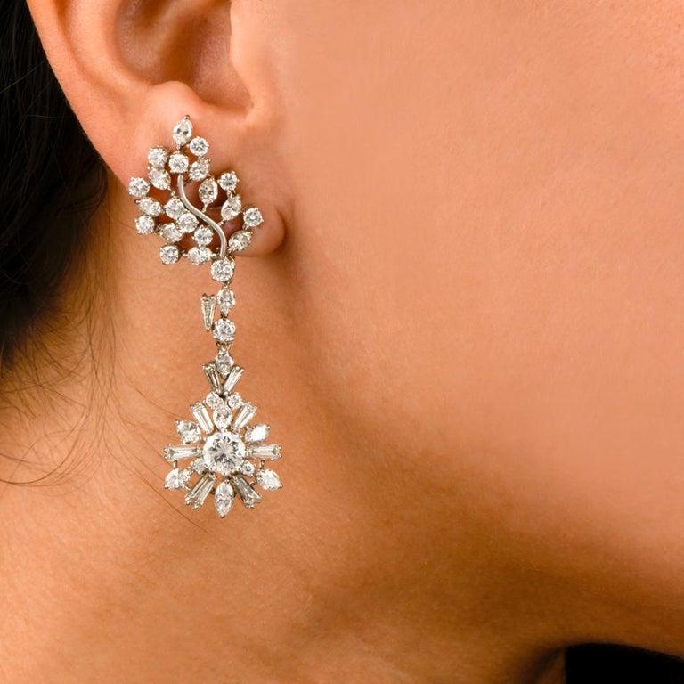 These 1960's chandelier drop earrings are crafted in solid platinum. Exposing a pair of diamond-swathed cluster profiles as ear clips. These exquisite drop earrings are adorned with 2 genuine high quality round cut diamonds approx. 1.52 carats in