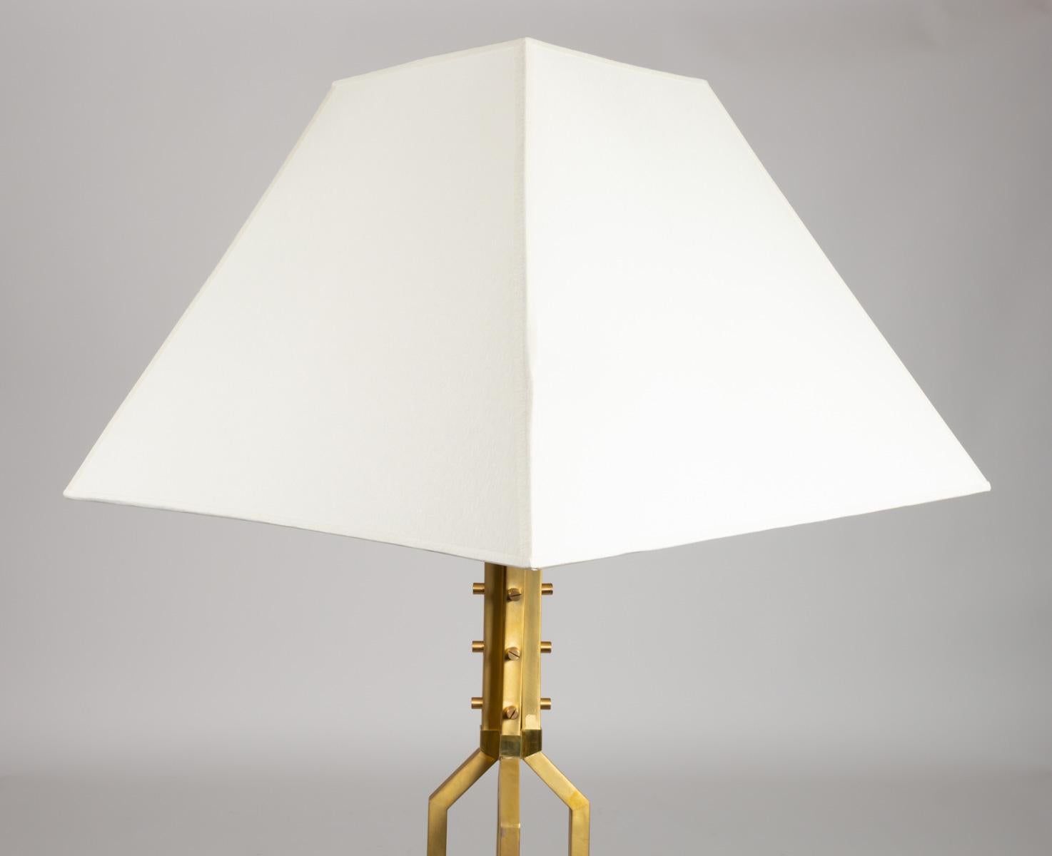 Elegant floor lamp all in golden brass.

The body is formed by four rods of square section joining and held together by pretty nuts at the base of the plinth.
This is composed of 4 flat brass rods forming a square assembled by the same nuts and
