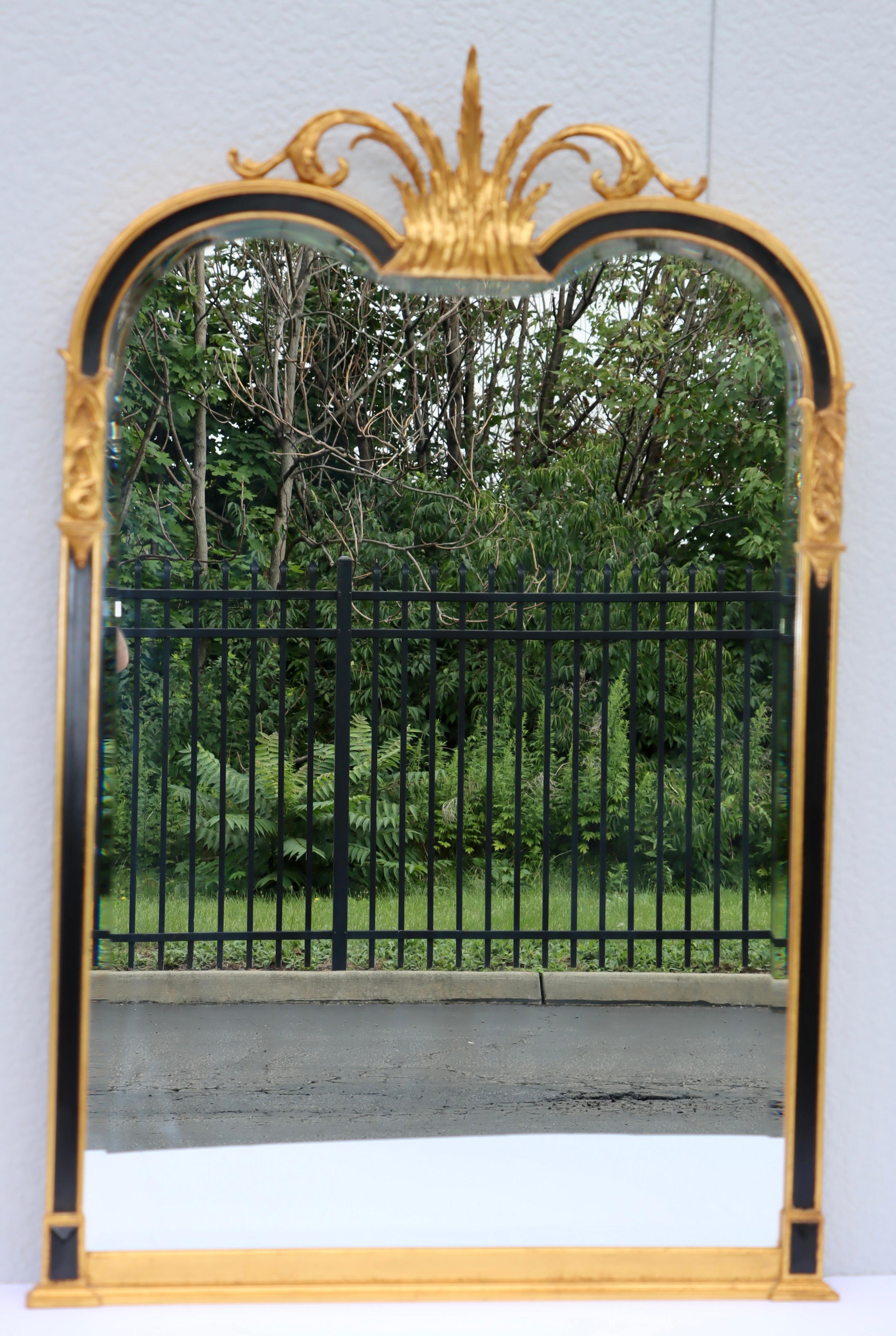1960's Hollywood Regency giltwood and lacquer beveled wall mirror by Carver's Guild, in very good vintage condition with minor wear and patina due to age and use.