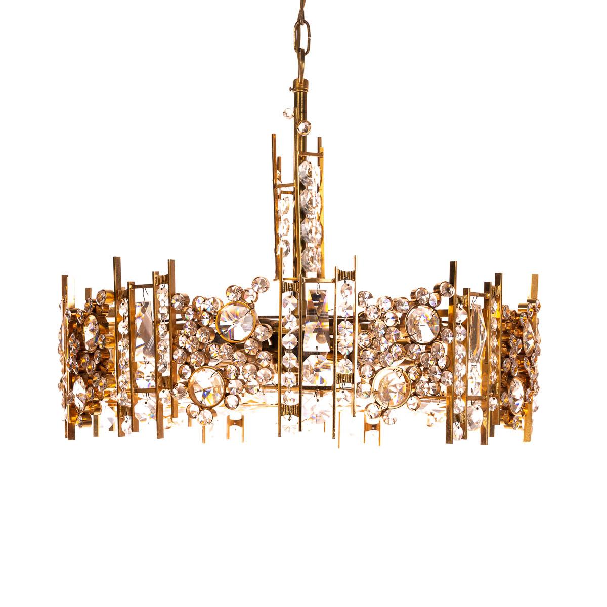This special and stunning chandelier by Palwa has handcrafted gilt brass rings encrusted with crystal glass, circa 1960s. It holds nine E14 lightbulbs.