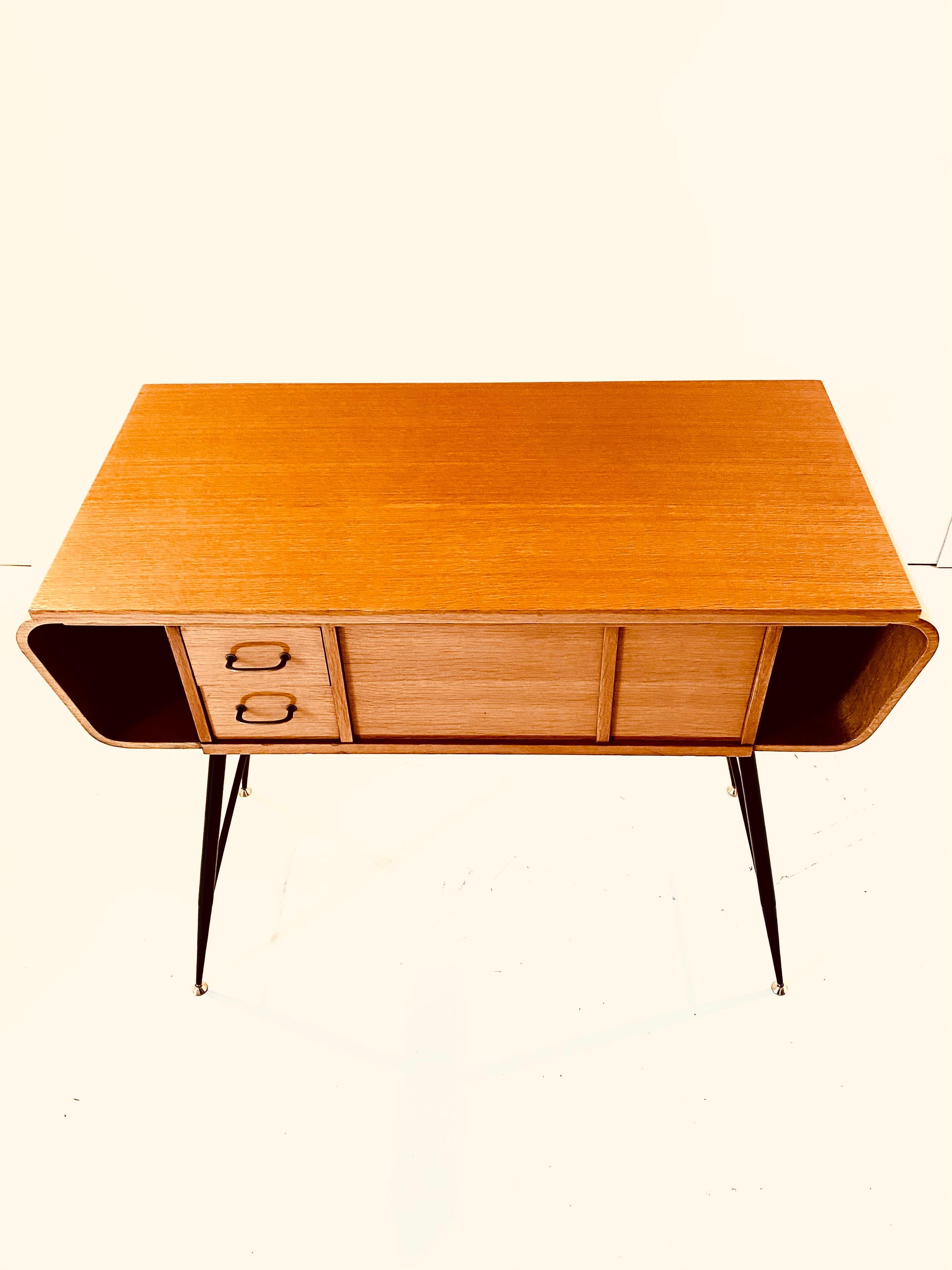 A rare 1960s Gio Ponti console table for Singer. Manufactured in Germany in the 1960s, the item is made of laquered oak wood, black iron legs and brass feet. The console has an openable top which used to close the section of the furniture where the