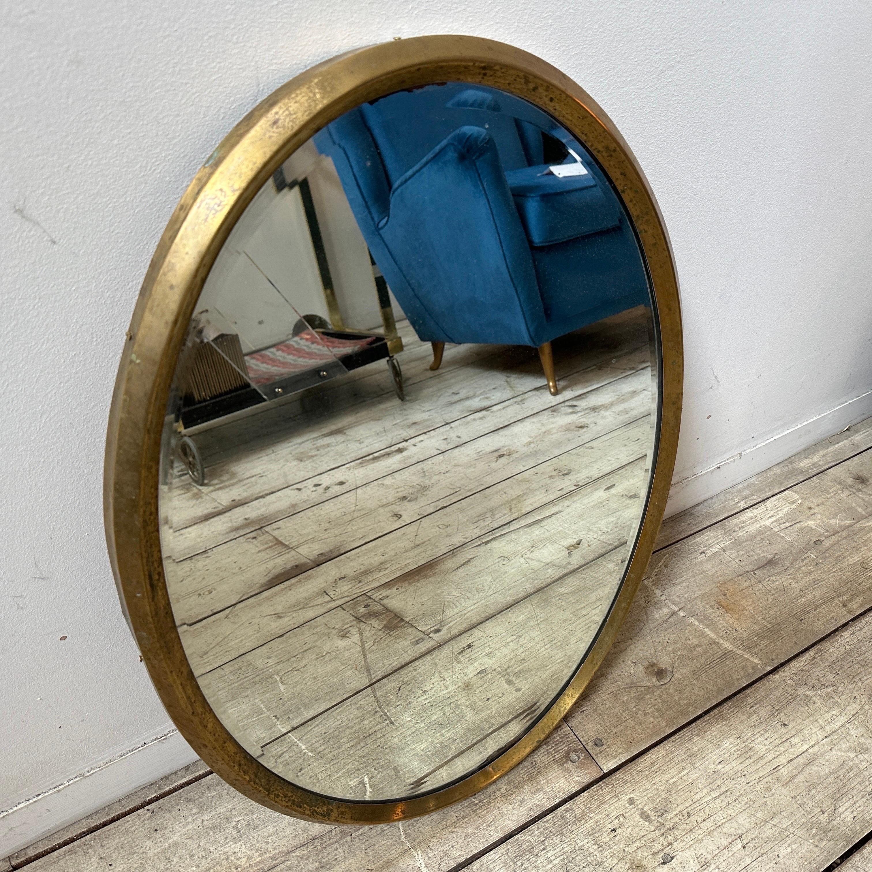 Miroir mural ovale en laiton massif conçu et fabriqué en Italie dans les années 50, le laiton est en patine d'origine et présente des signes d'utilisation et d'âge, le verre du miroir est celui d'origine. Les années 1950 ont été une période de