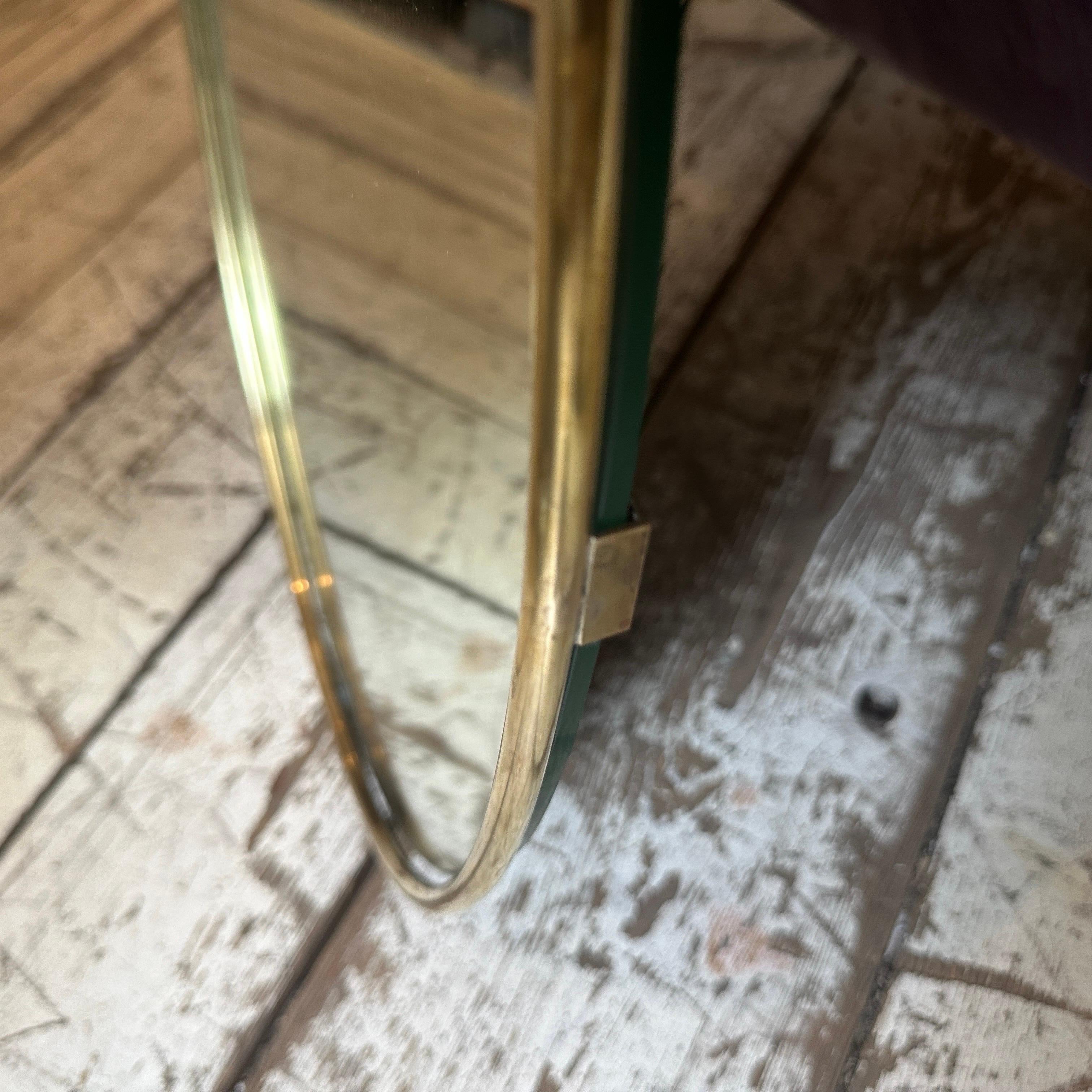 A solid brass wall mirror designed and manufactured in Italy in the Fifties, brass it's in original patina and has signs of use and age, mirror glass is the original one. The 1950s was a period of great creativity and innovation in the world of