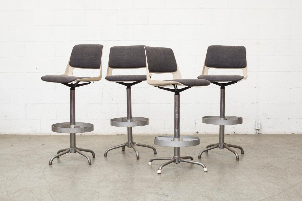 Designed in 1960s by A.R. Cordemeyer for Gispen, these BZ 1802 bar height stools have very original metal frames with new charcoal upholstery and spring swivel. 4 currently available in gray, others available with similar frames. Frames in VERY