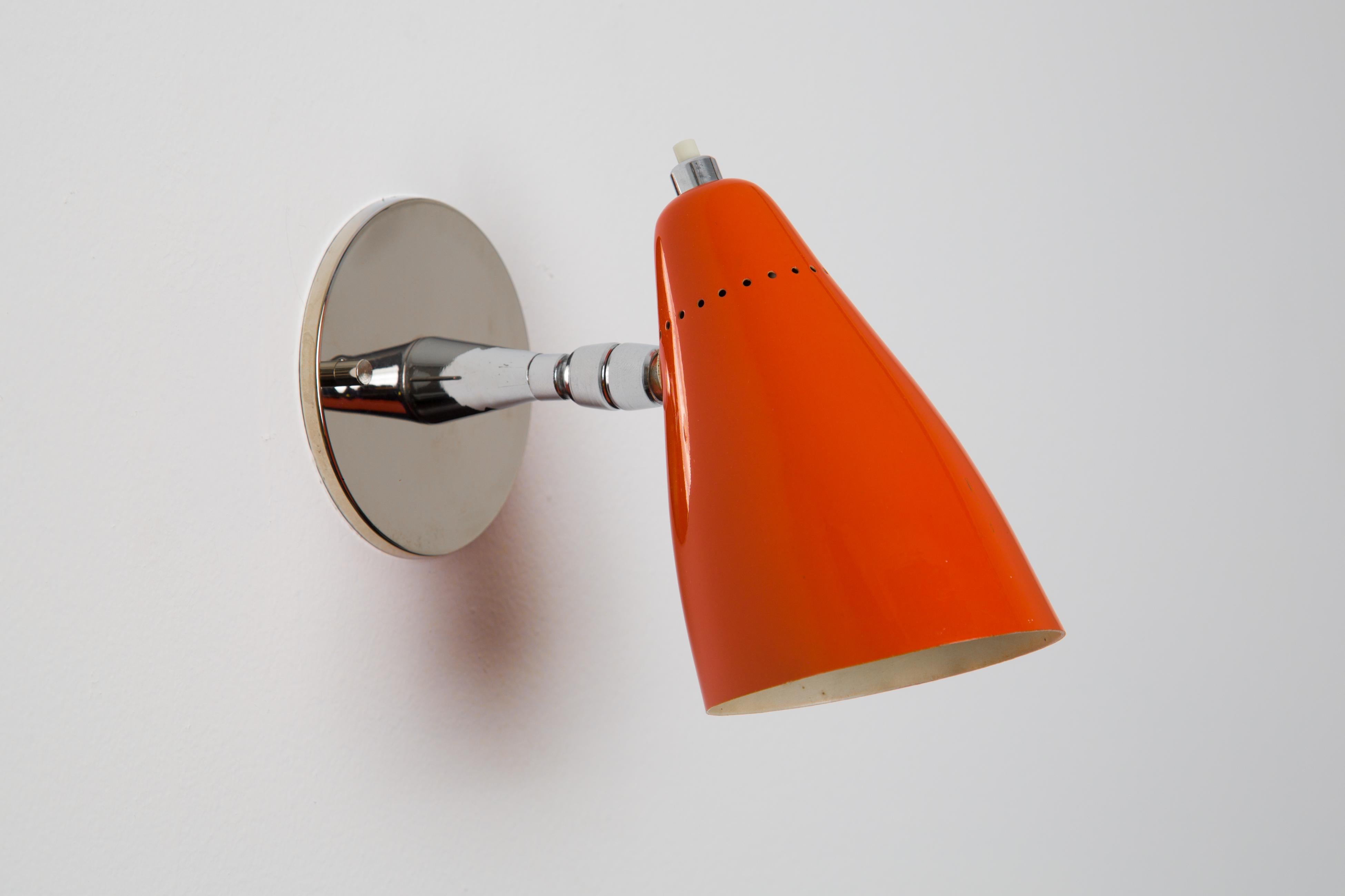 1960s Giuseppe Ostuni Model #101 orange articulating sconce for O-Luce. Executed in polished chrome and a orange painted perforated aluminum shade. Sconce pivots up/down and left/right. An incredibly clean and refined design by one of the Italian