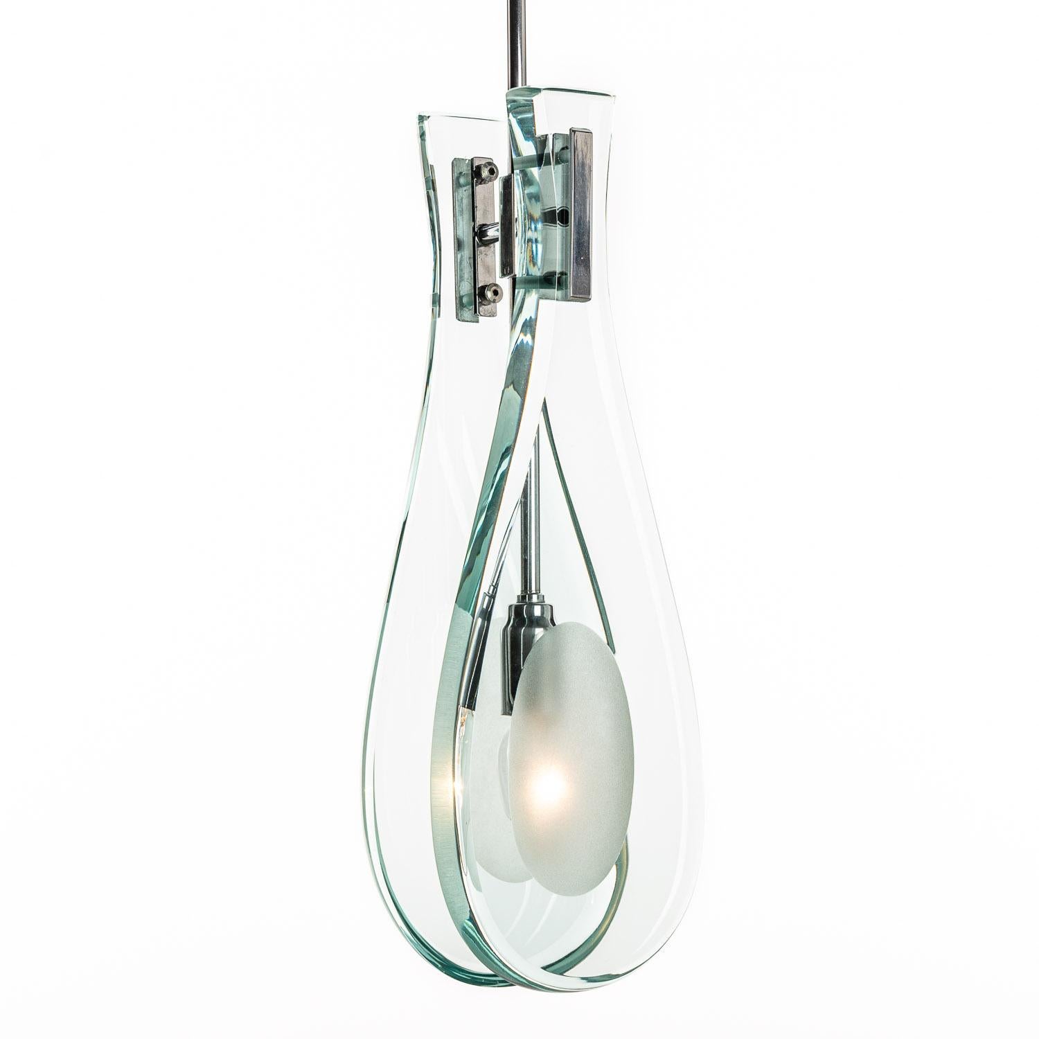 Classic drop-shaped pendant designed by Max Ingrand.
Two thick and heavy glass panels with frosted glass center to diffuse the single E14 lightbulb. 
We als have one with brown/yellow tone glass panels and a large pendant with not one but with 