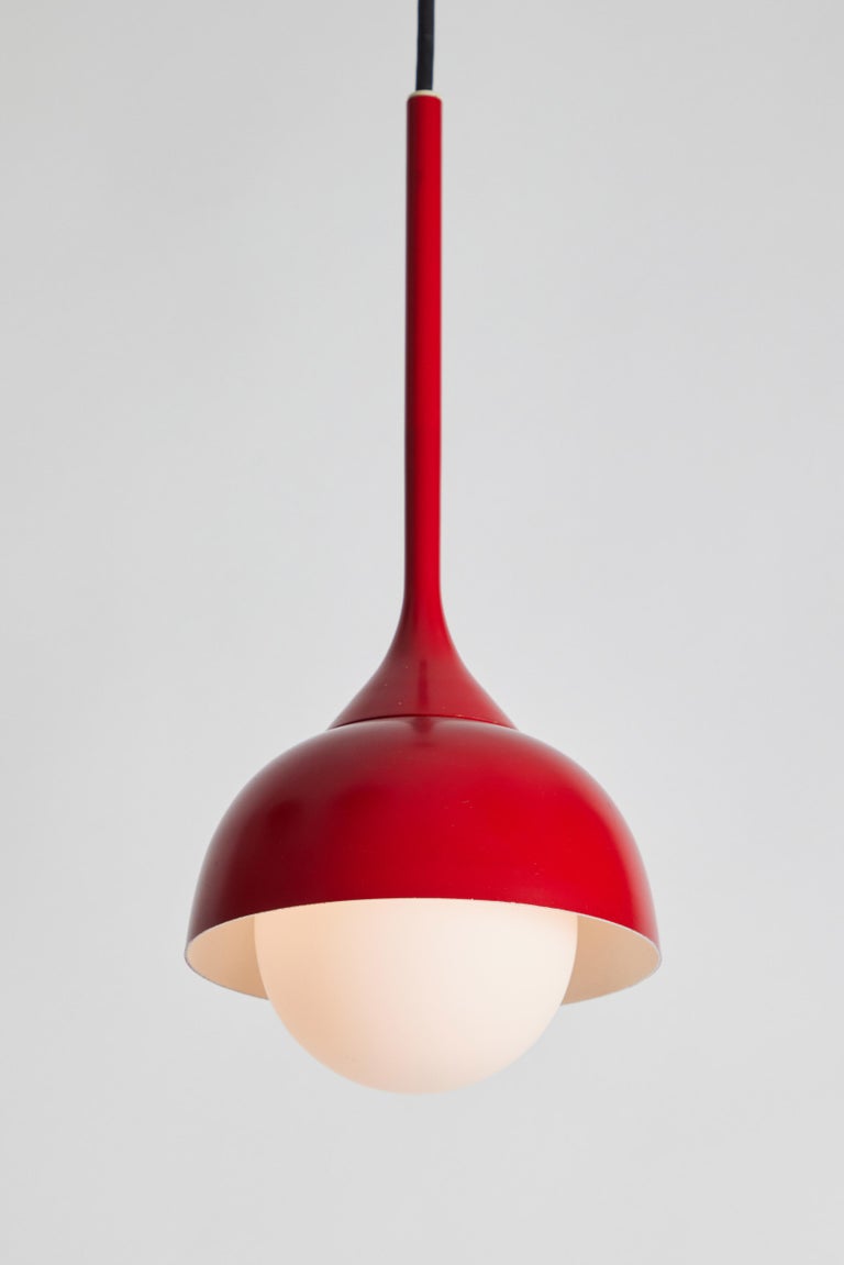 1960s glass and red painted metal pendant attributed to Stilnovo. A quintessentially 1960s Italian design executed in opaline glass and red painted metal with custom ceiling canopy for mounting over a standard American J-box. A highly functional and