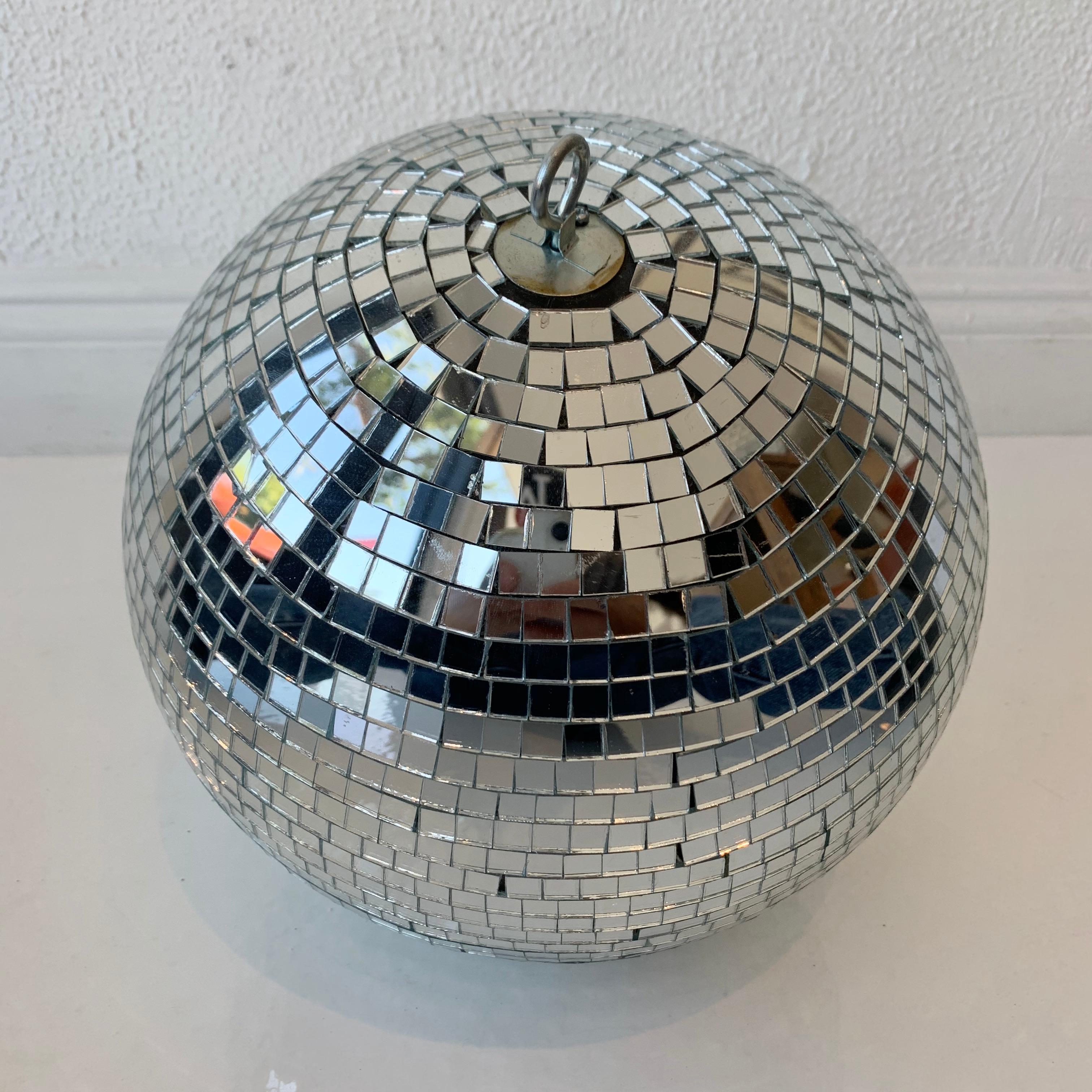 Great retro disco ball made out of miniature square pieces of glass. Good condition. Illuminates beautifully. Sold with a metal chain. Can adjust overall height before shipped out.

Measurements: Diameter of ball is 12.