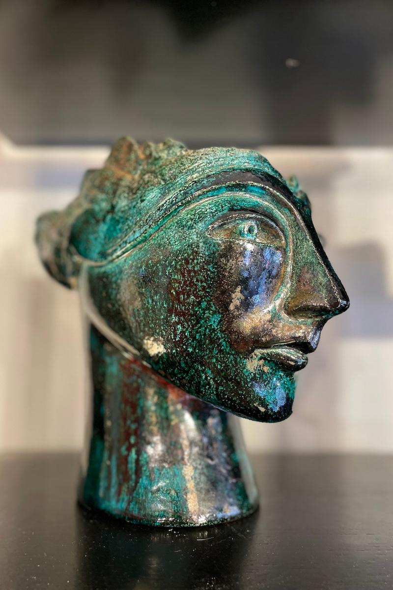 Sculpture représentant une tête, réalisée en céramique émaillée dans des tons allant du noir au vert. Un ouvrage des années 1960. 
Dimensions : 28 × 15 × h 24 cm.

Le prix INCLUT le coût de l'emballage et des caisses nécessaires pour protéger