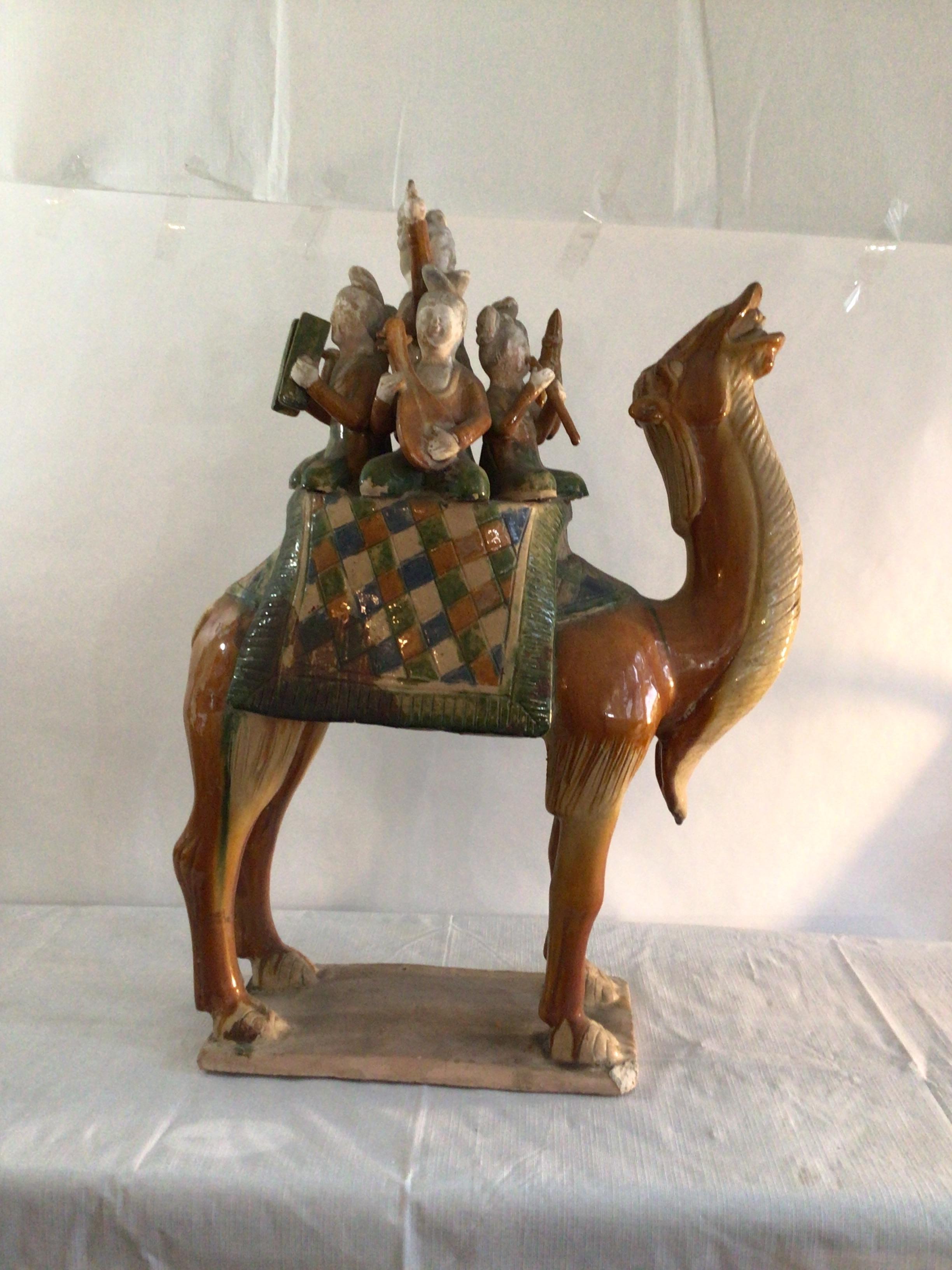 1960s Glazed Sculpture Of A Camel Carrying Musicians
Chinese style terra cotta tomb figure carrying a band of musicians
The figurine utilizes: brown, green, blue and off-white pigments
One of the front corners - piece missing (as shown in picture)
