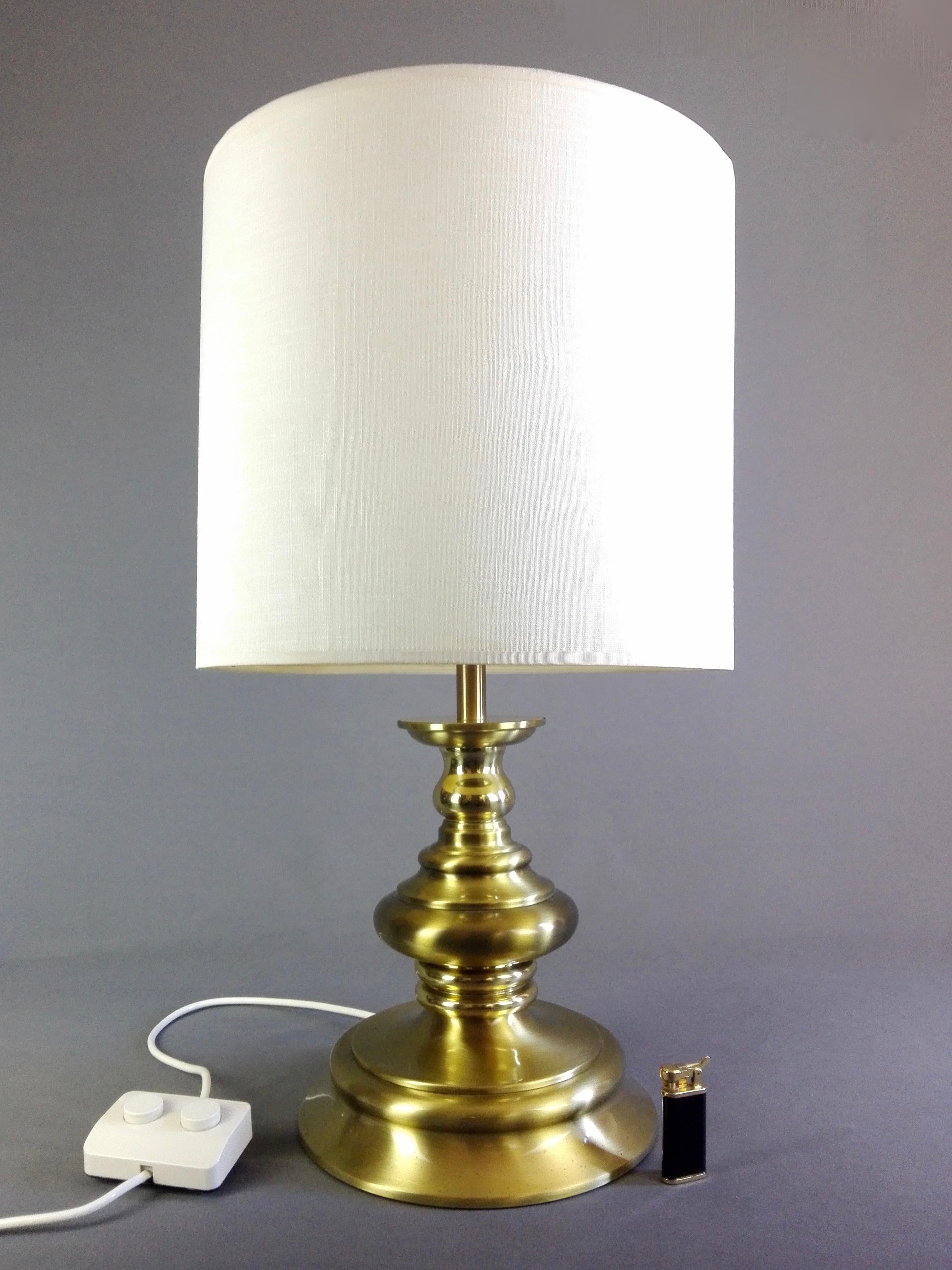 Beautiful and large Reggiani 1960s three-light table or floor lamp in solid brass, with double on/off switch and original textile lampshade. The frame is composed of various elements in brushed brass and some with a polished finish creating a