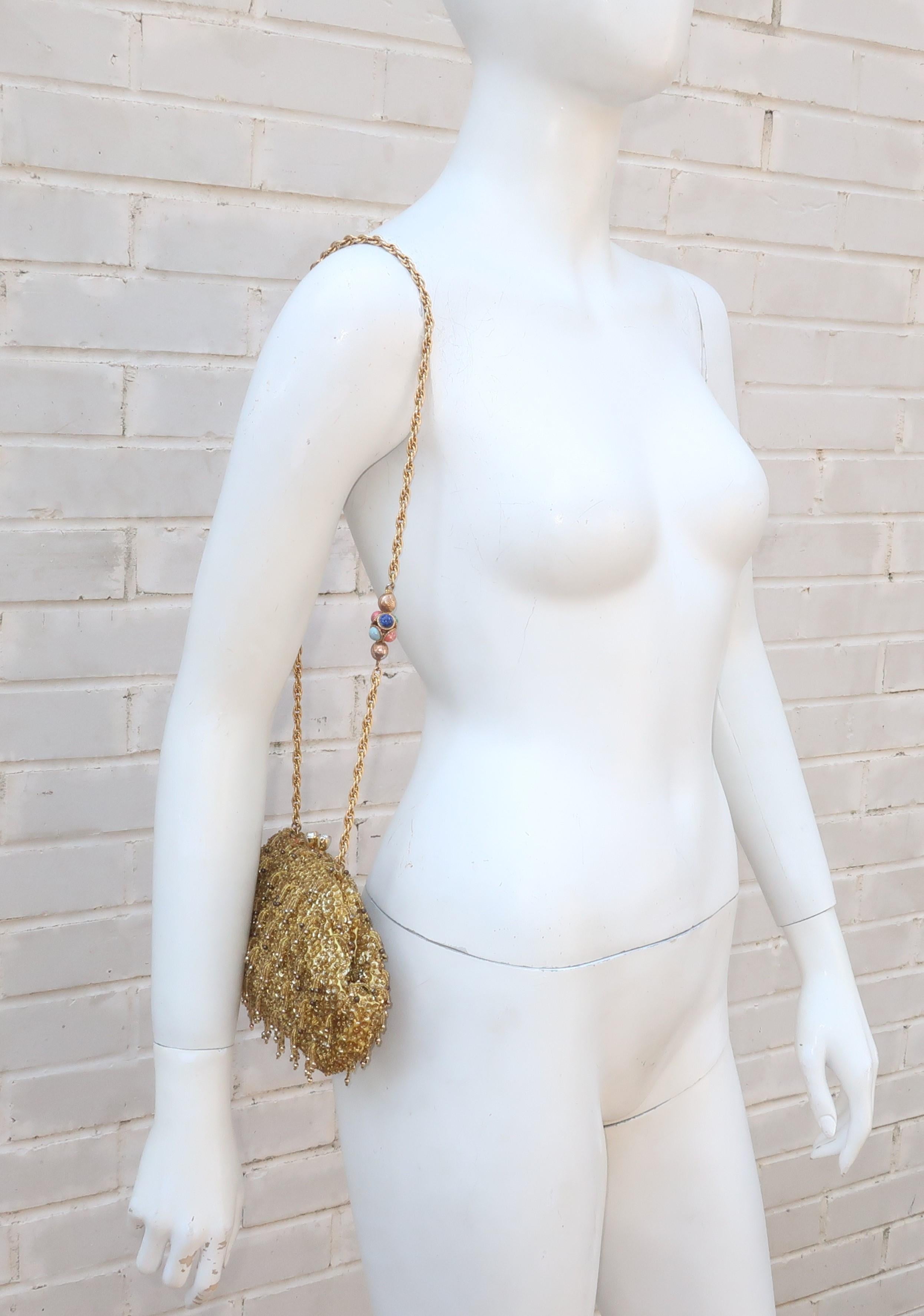 Add a touch of 1960's swinging style to an evening ensemble with this gold sequin and beaded handbag.  The yellow satin body of the handbag is fully embellished with gold sequins and dangling gold seed beads that give the design a fringe effect. 