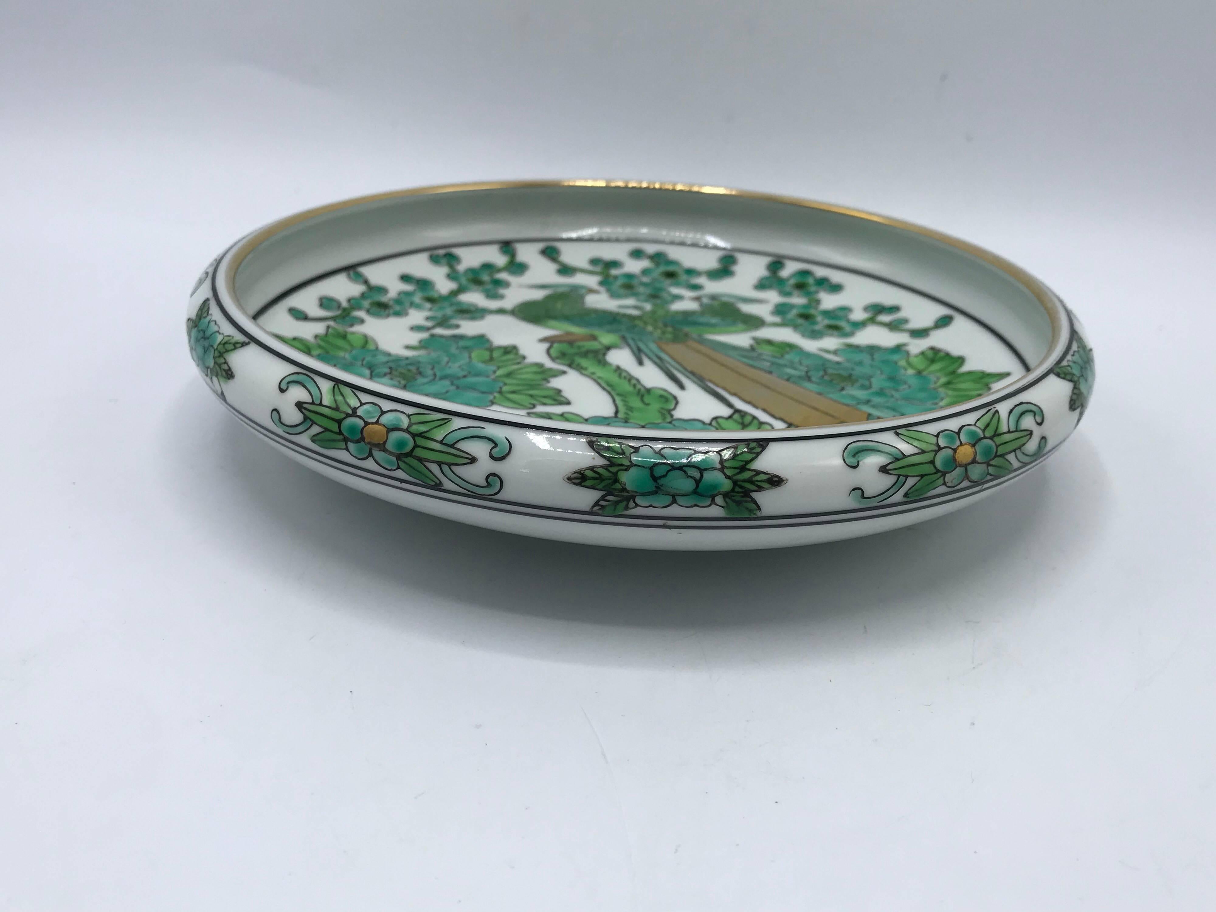 Listed is a beautiful, 1960s gold imari, green and white dish. The piece has a gorgeous peacock motif with gold accents. Marked ‘Gold Imari’ on bottom side.
