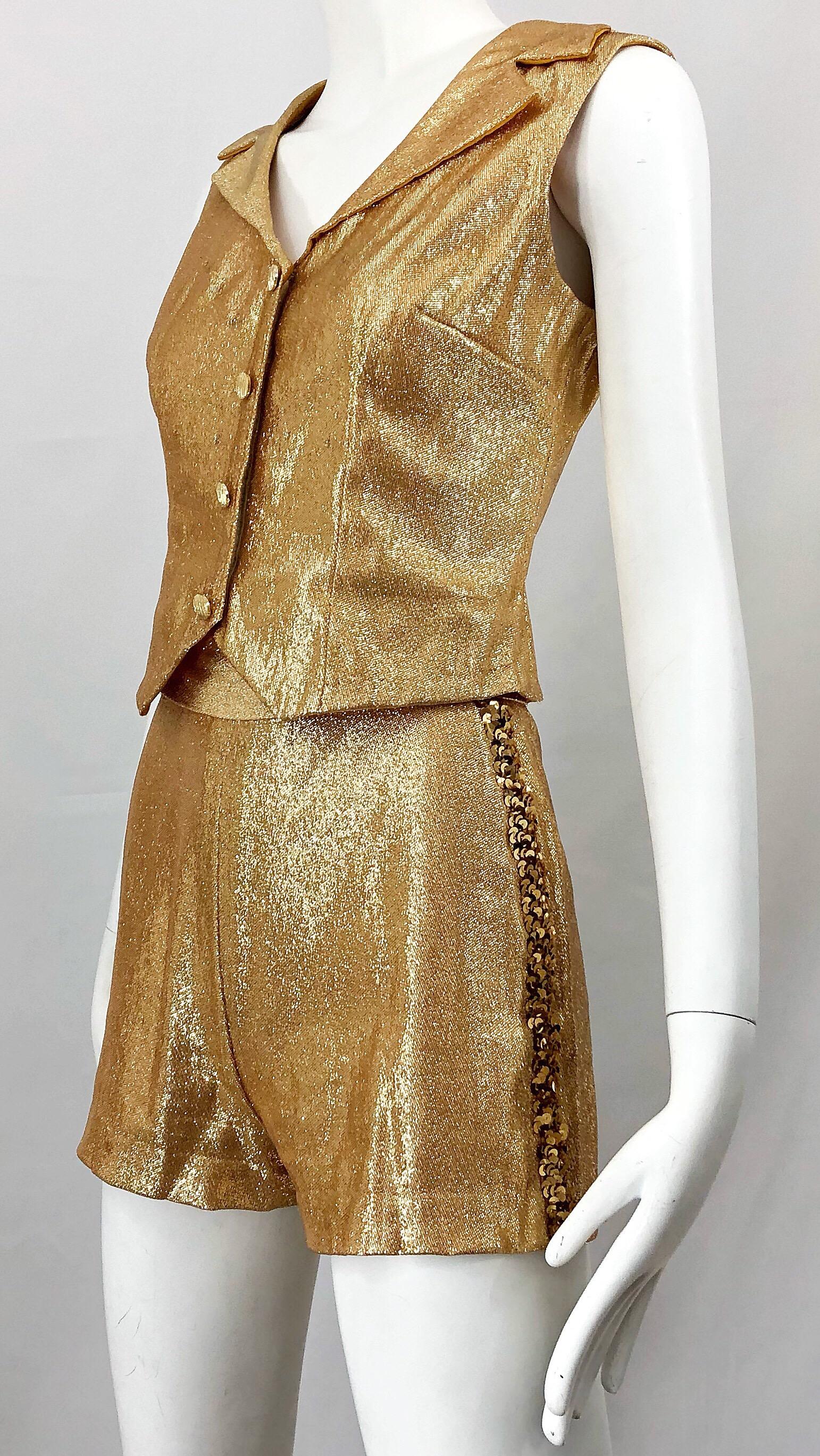 Awesome authentic 1960s gold Lurex matching band themed ensemble! Features high waisted shorts with metal zipper up the back and hook-and-eye closure. Hundreds of hand-sewn sequins down the side of each outer leg. Fitted vest style top features four