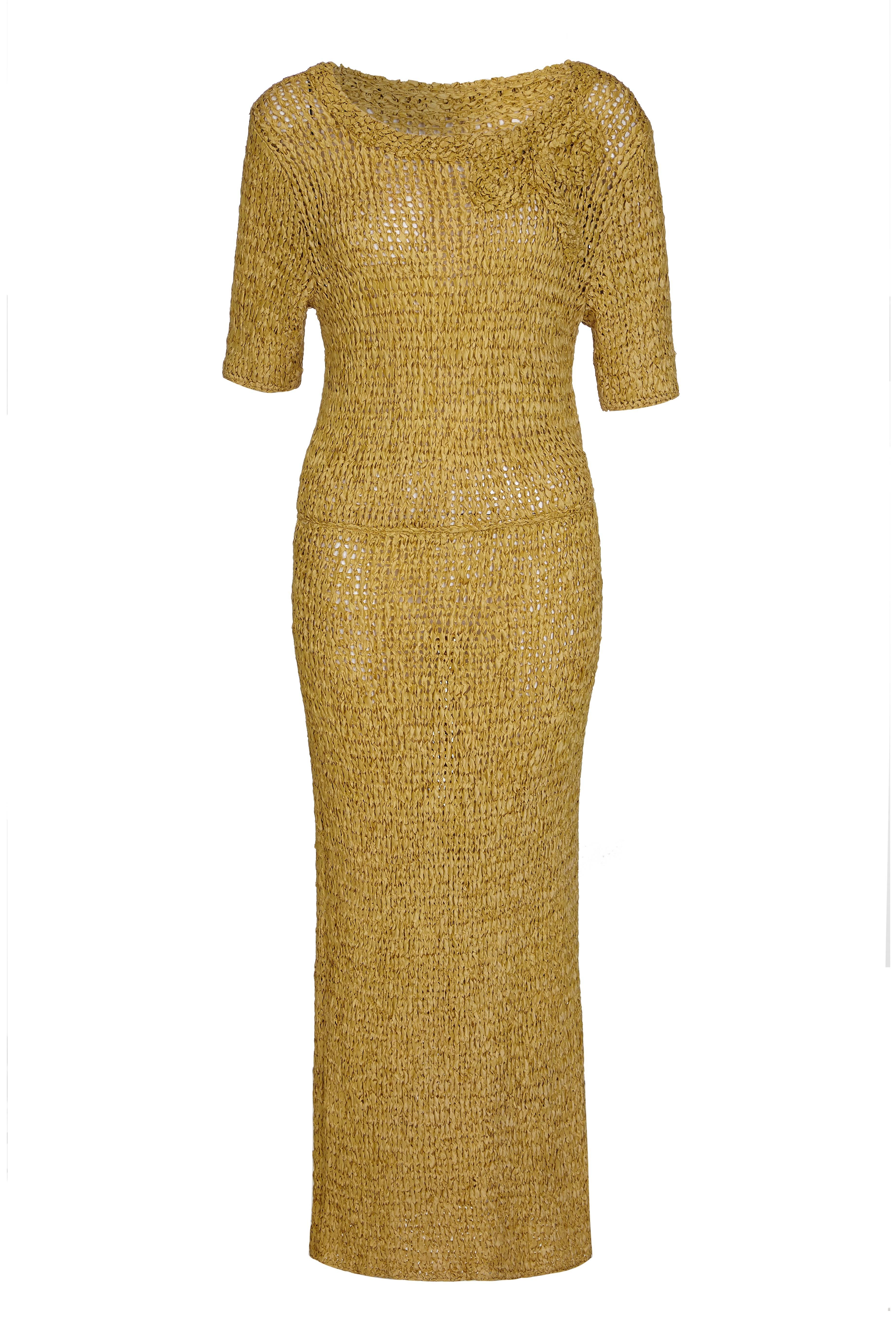 This elegant 1960s woven ribbon work wiggle dress in deep ochre is in superb vintage condition and is an unusual and collectable piece. The dress has elbow length sleeves, elasticated waistline and a scoop neckline featuring a ribbon work appliqué