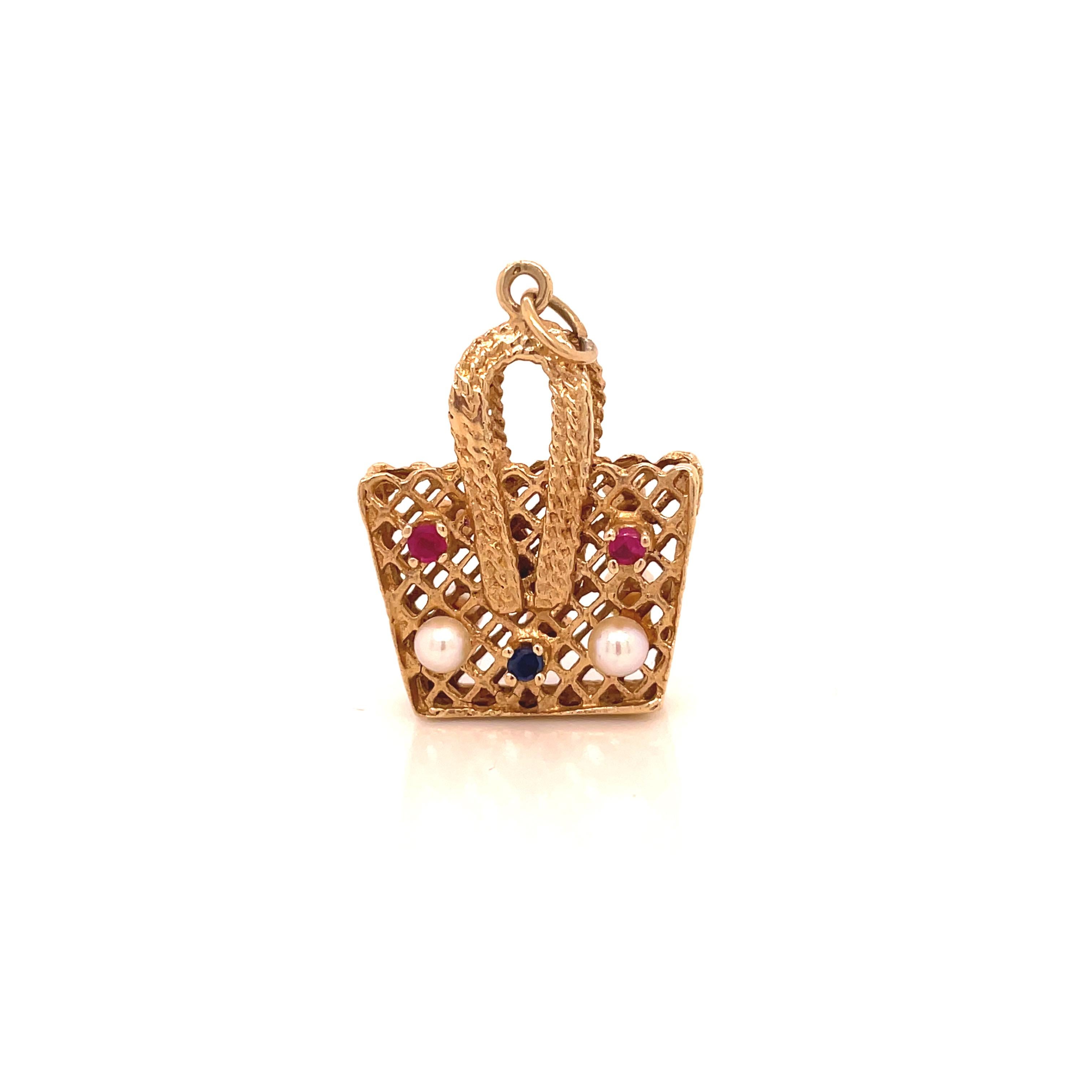 This is a darling 14K yellow gold picnic basket charm that dates back to the 1960s decorated with beautiful rubies, sapphires, and freshwater pearls! This little picnic basket is just too cute! Wear it as a pendant or attach it to your charm