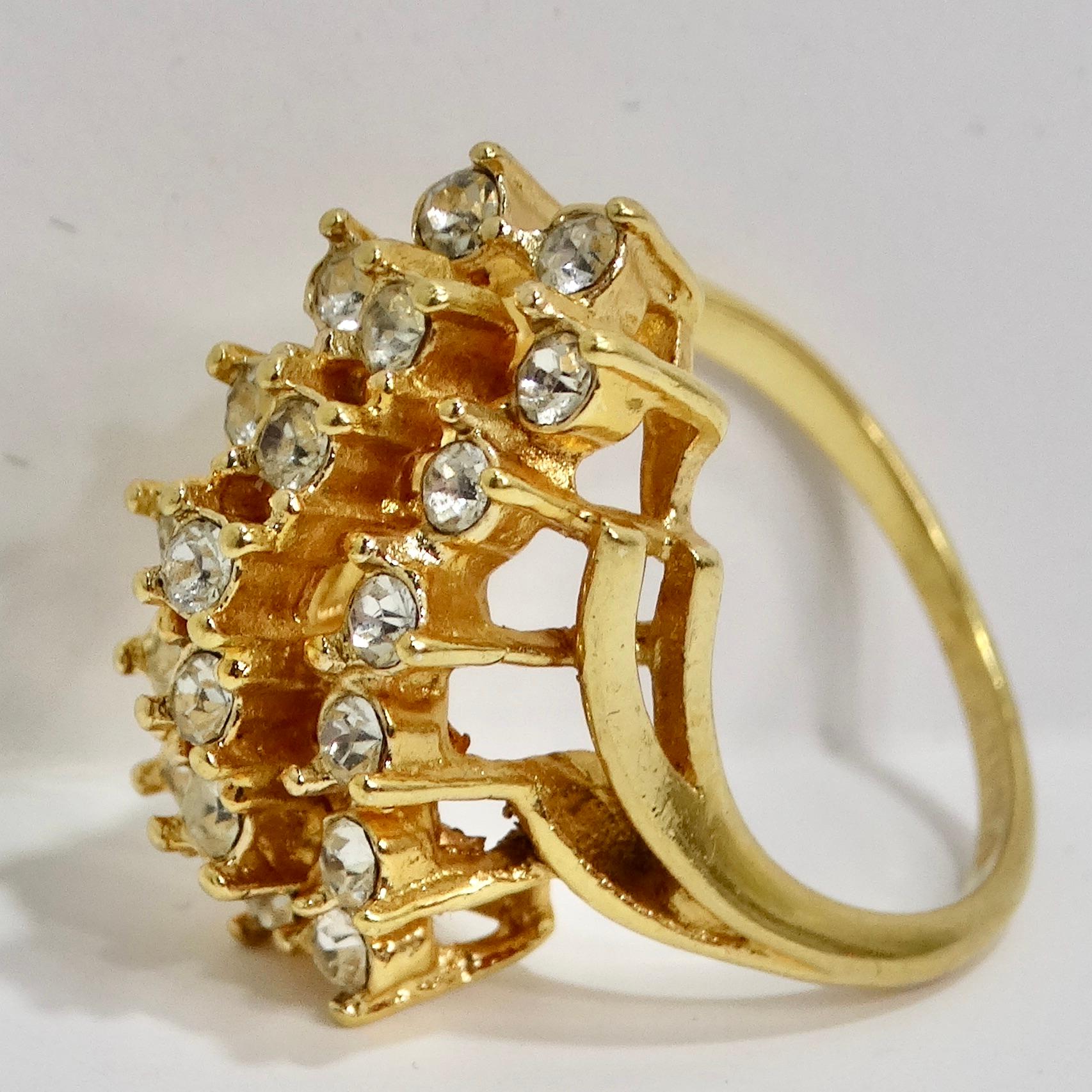 Entfesseln Sie den Glamour der 1960er Jahre mit unserem exquisiten vergoldeten Strasssteinring. Dieser atemberaubende Clusterring ist ein Beweis für zeitlose Eleganz und die Kunst, ein glamouröses Statement abzugeben. Dieser Ring ist mit einer