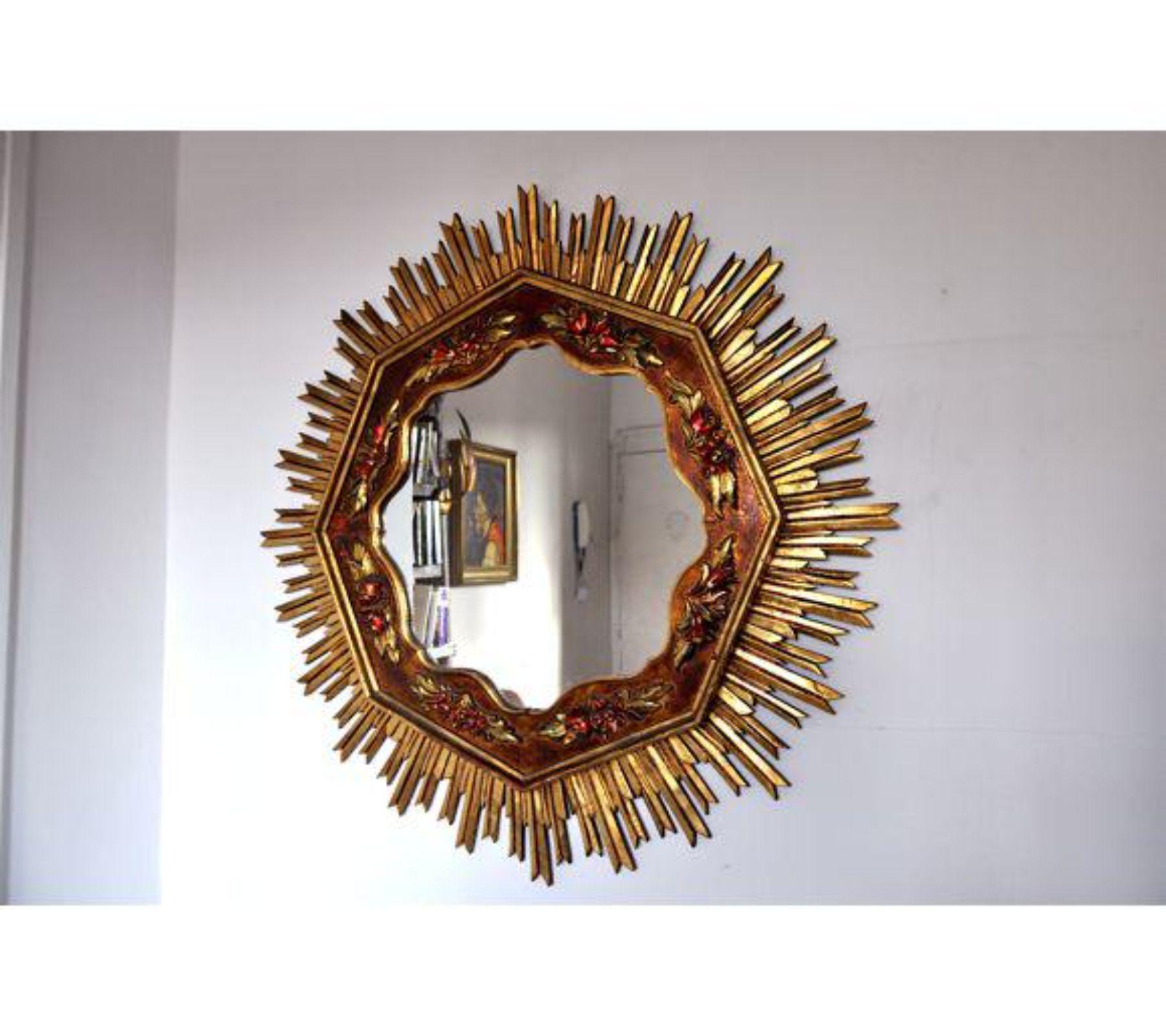 Large gold sunburst wodden mirror designed and hand crafter in France in 1960. Superb wood work with floral representation, unique by its size. A unique piece of design that will be great a highlight to your interior project. Object in mint