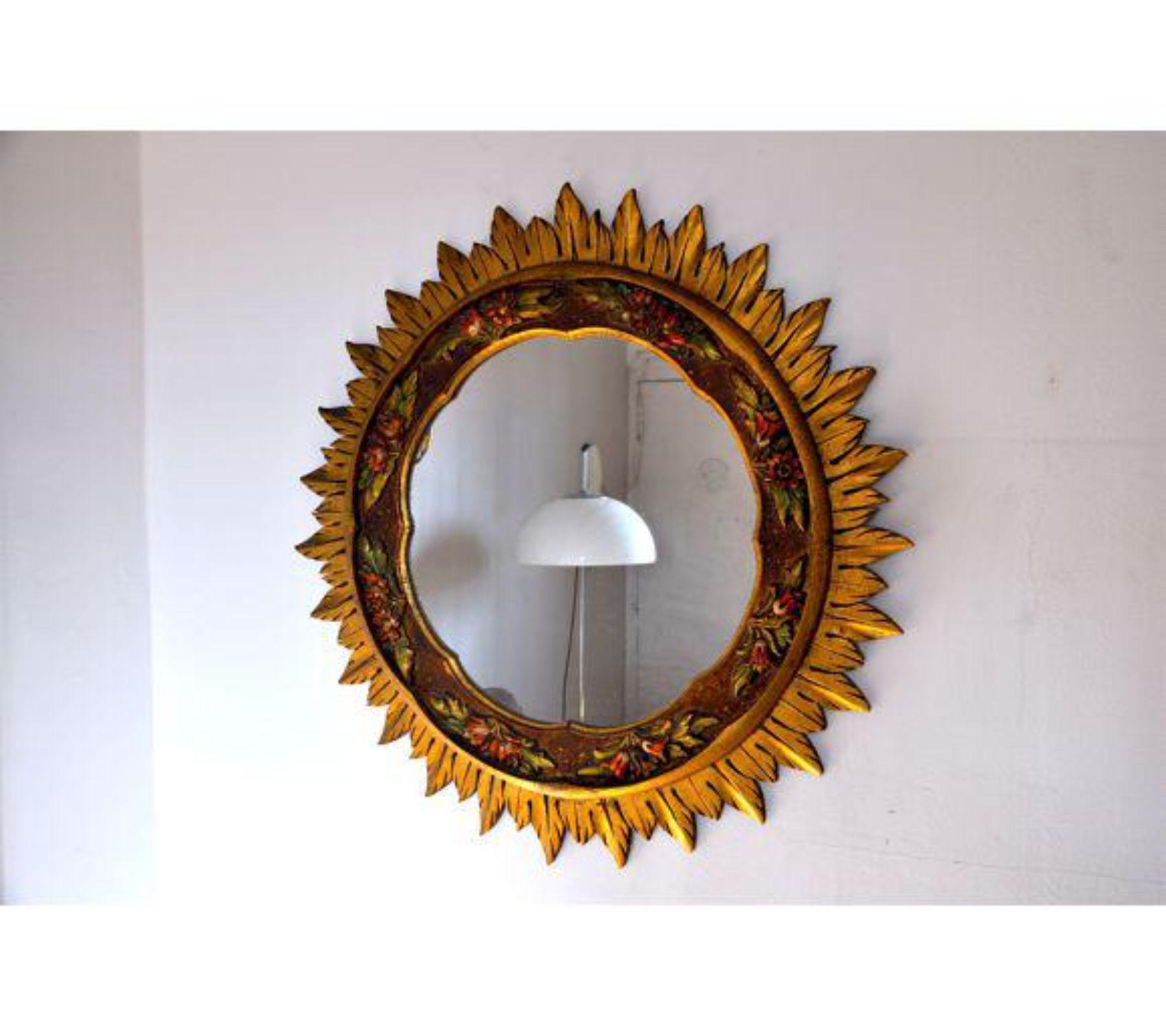 Large gold sunburst wodden mirror designed and hand crafter in France in 1960. Superb wood work with floral representation, unique by its size. A unique piece of design that will be great a highlight to your interior project. Object in mint