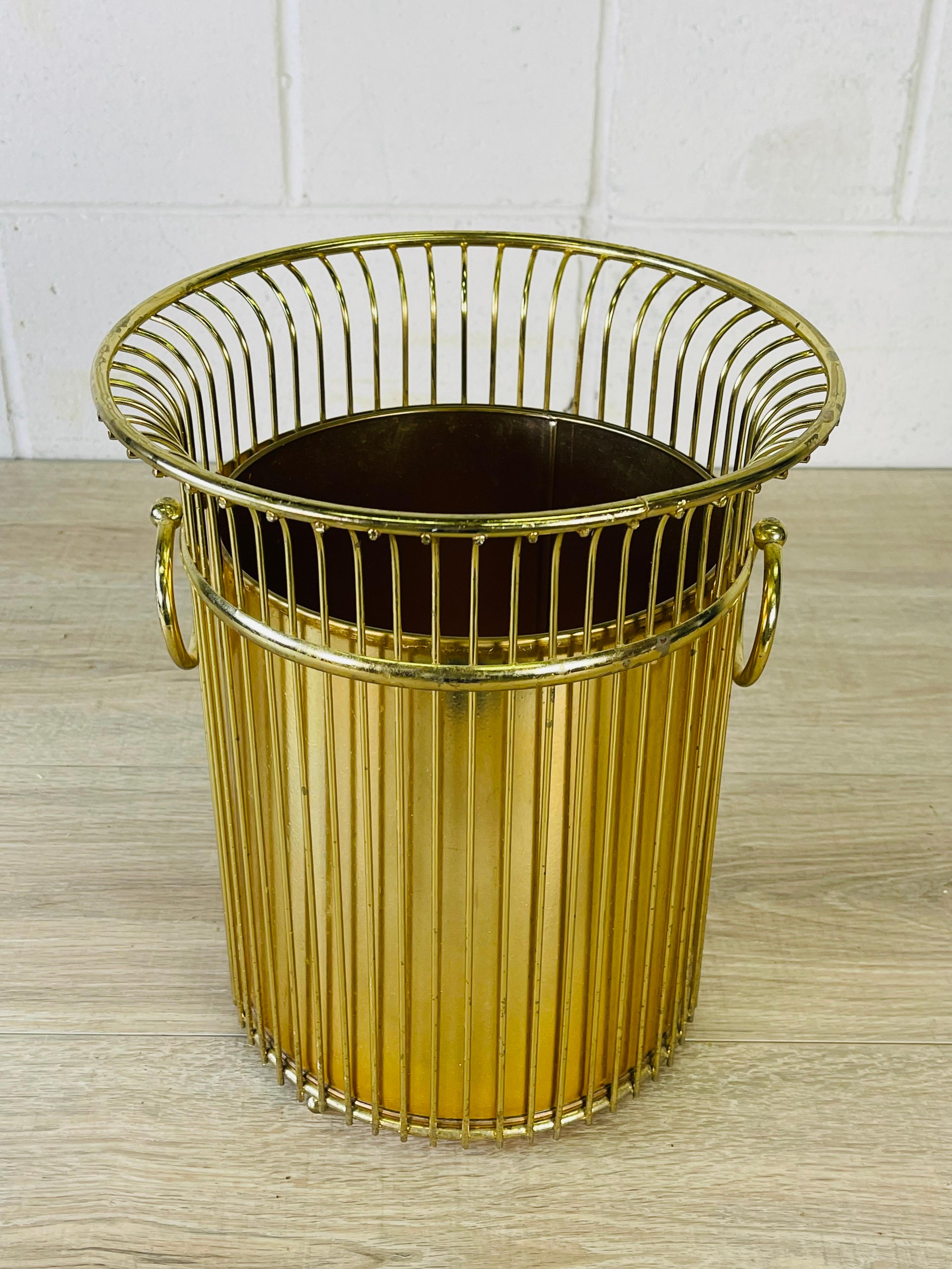 Vintage 1960s wire handled gold wastebasket with liner. No marks.