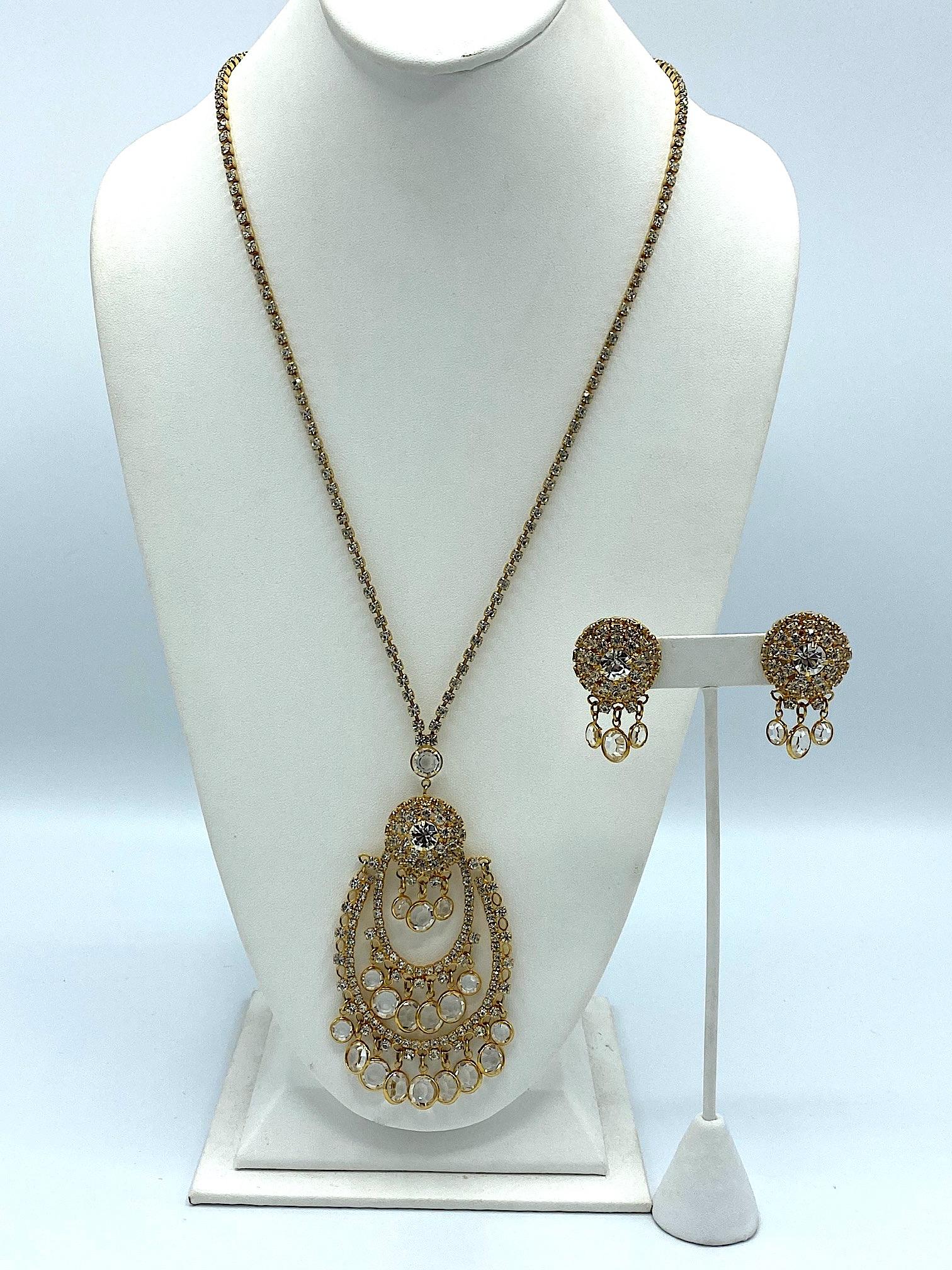 From the Golden Age of Rhinestones is this stunning necklace and earring set circa 1960 to 1965. The necklace and earrings are gold plate with prong set rhinestones and faceted round crystal dangles. The necklace strand of rhinestones is 24 inches