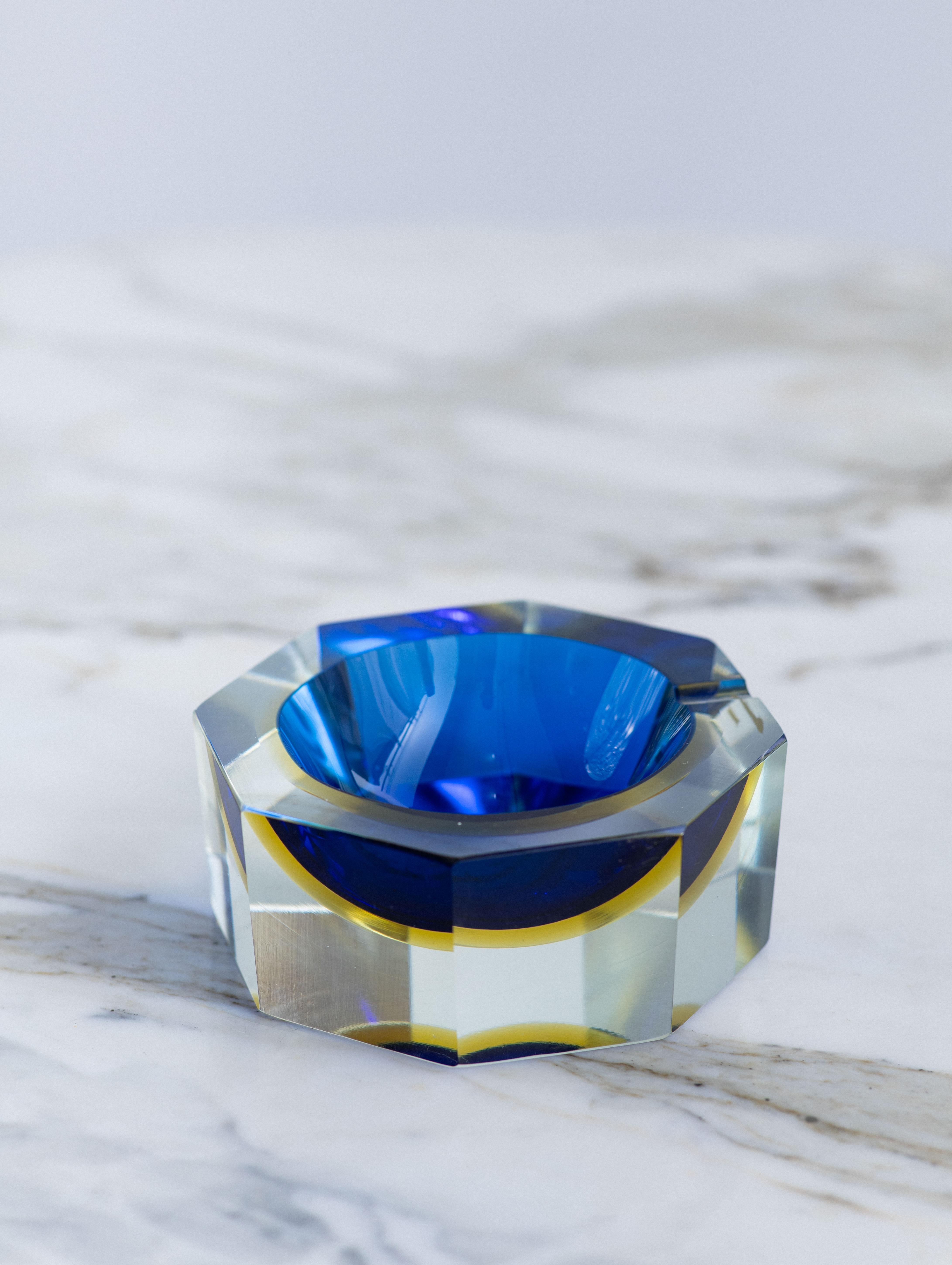 Mid century Murano sommerso glass ashtray by Golden Crown E & R Italy. Octagon form. Cut facets show inner cobalt and yellow colors. Retains original manufacturer stickers.

Sommerso is the glassmaking technique of creating two or more layers of