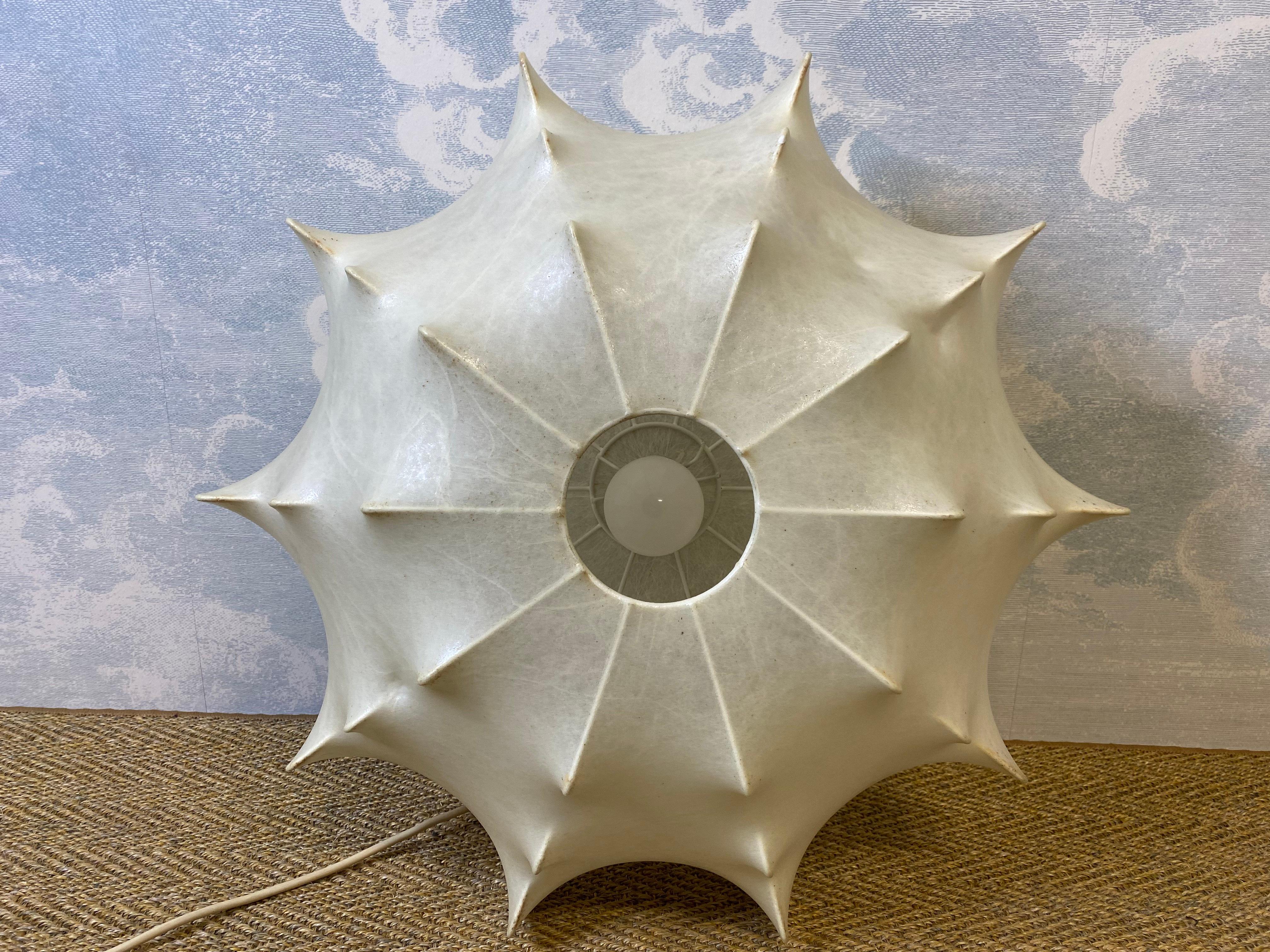 Questa rara e stravagante lampada a sospensione a forma di bozzolo degli anni '60 è in ottime condizioni e, data la sua età, mostra pochissimi segni di utilizzo.

Il Coccon ha un diametro del corpo di circa 56 cm e un'altezza di 30 cm e offre una