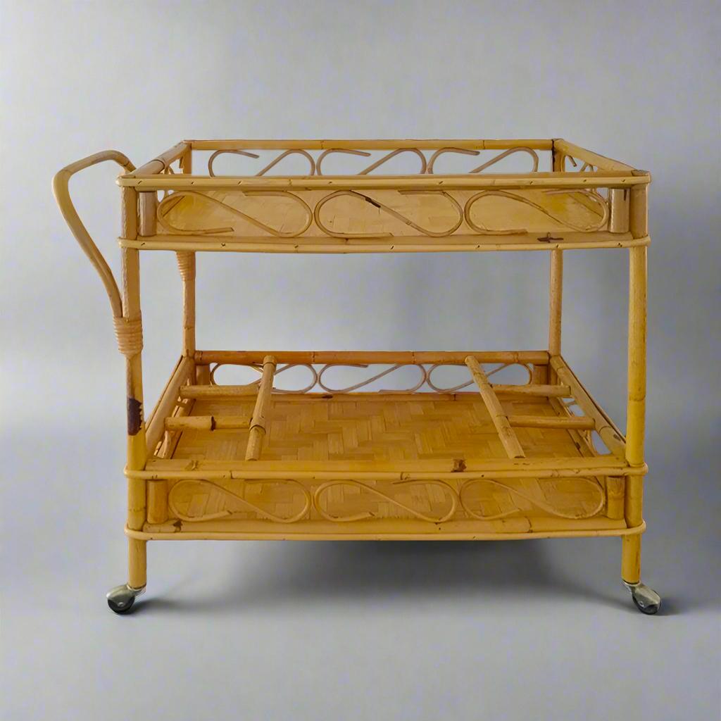 1960s Gorgeous and elegant serving bar cart in bamboo & rattan by Franco Albini. The structure featuring two shelves, the lower one features six bottle holders. Made in Italy. The cart is in excellent condition.
27,55 x 15,35 x 24,40 H inches
cm 70